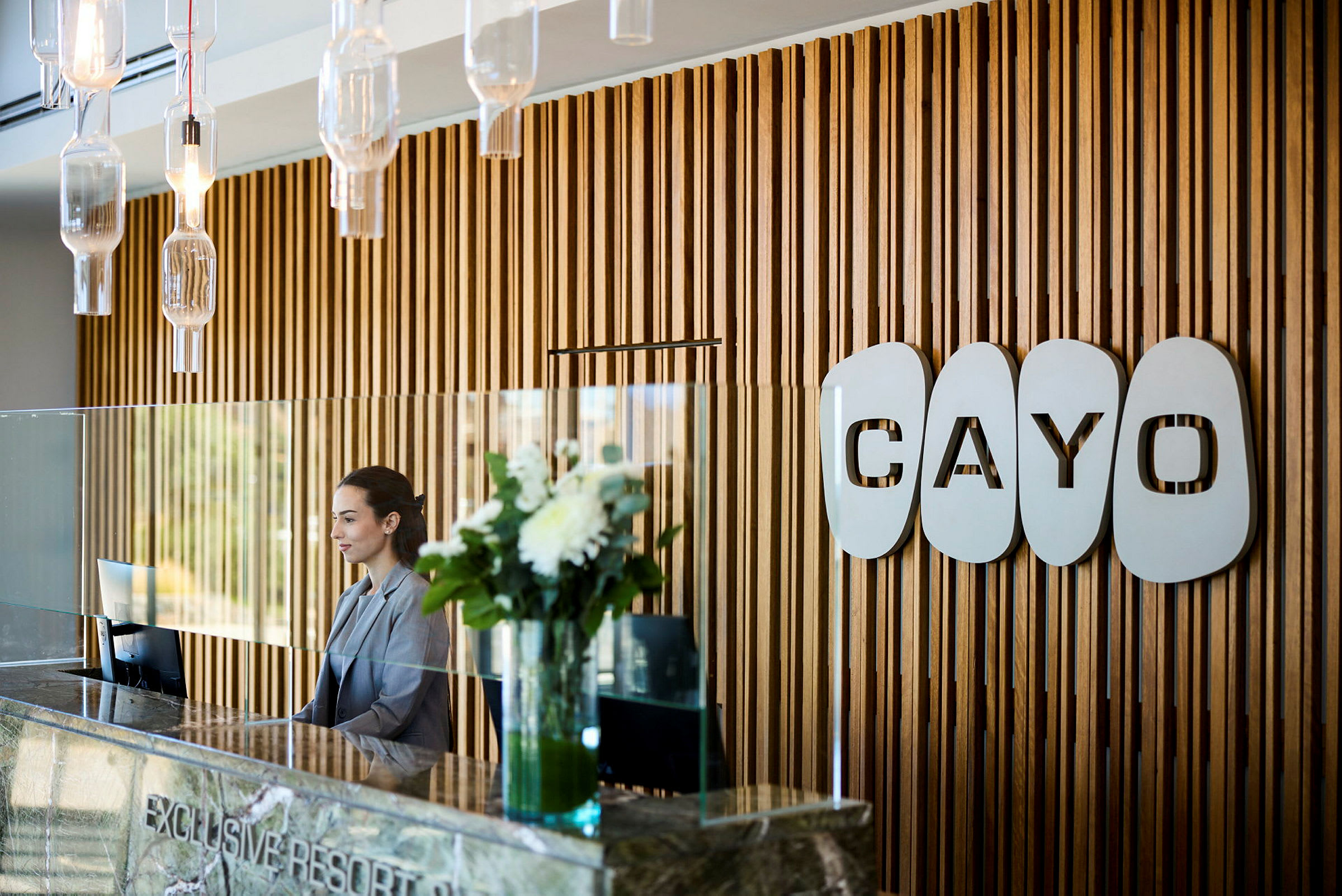Reception med träpaneler vägg och logotypen 'Cayo'. (AI-genererad text)