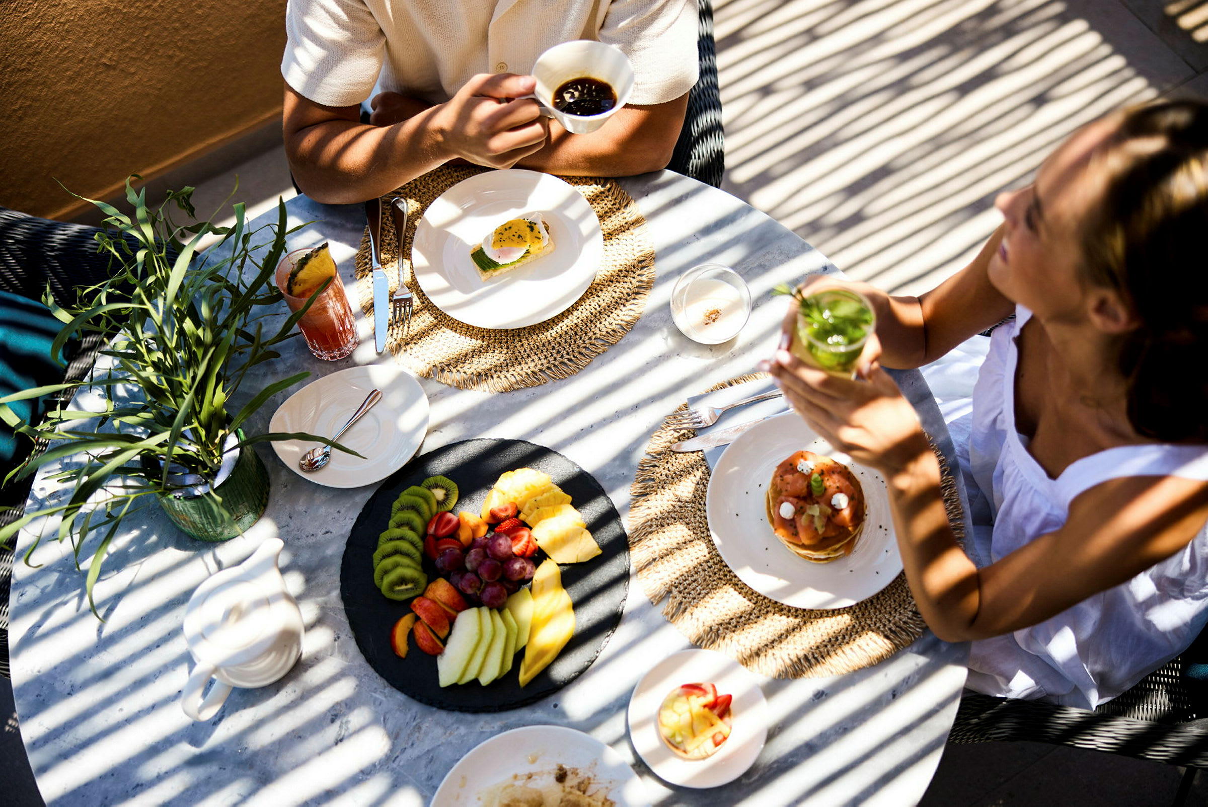 Personer sitter vid ett bord med olika maträtter och drycker. (AI-genererad text)