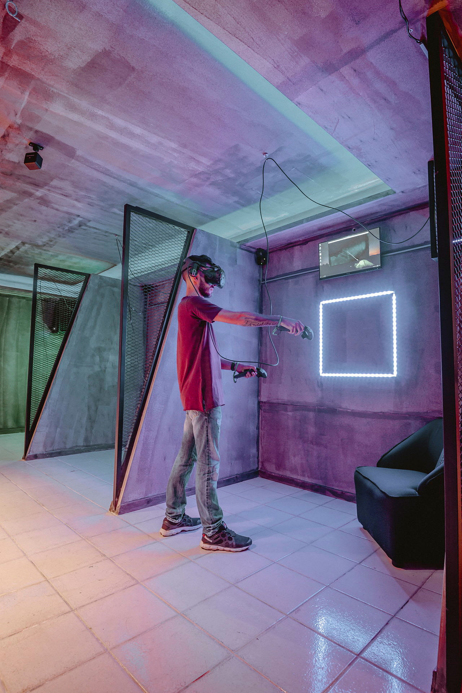 En person använder VR-glasögon i ett färgglatt rum med modern inredning. (AI-genererad text)
