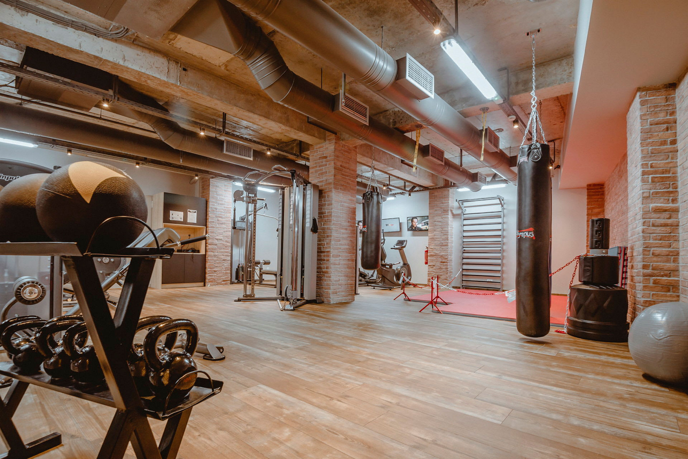 Gym med träningsutrustning, boxningssäck och vikter. (AI-genererad text)