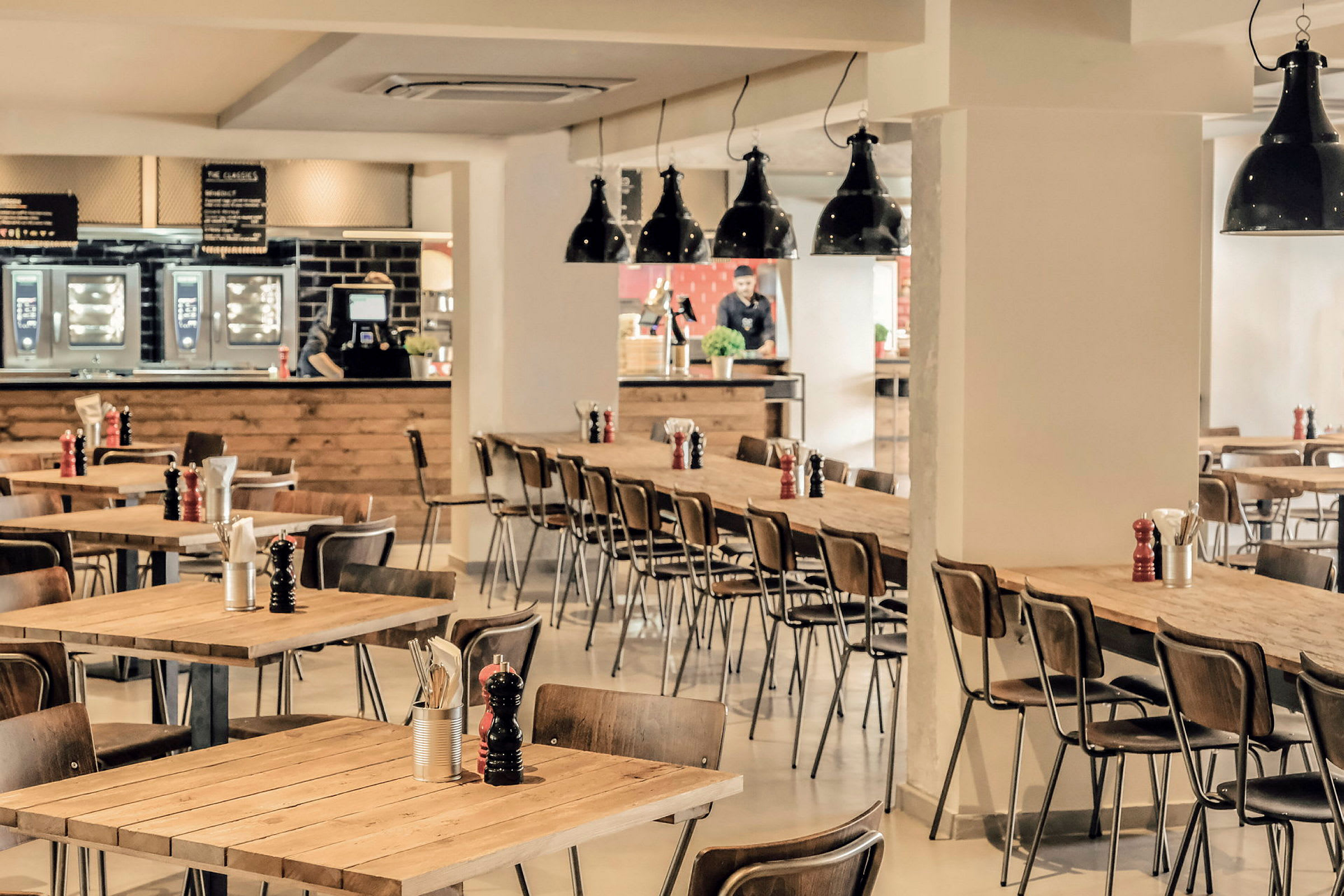 Interiör av en restaurang med träbord och stolar. (AI-genererad text)