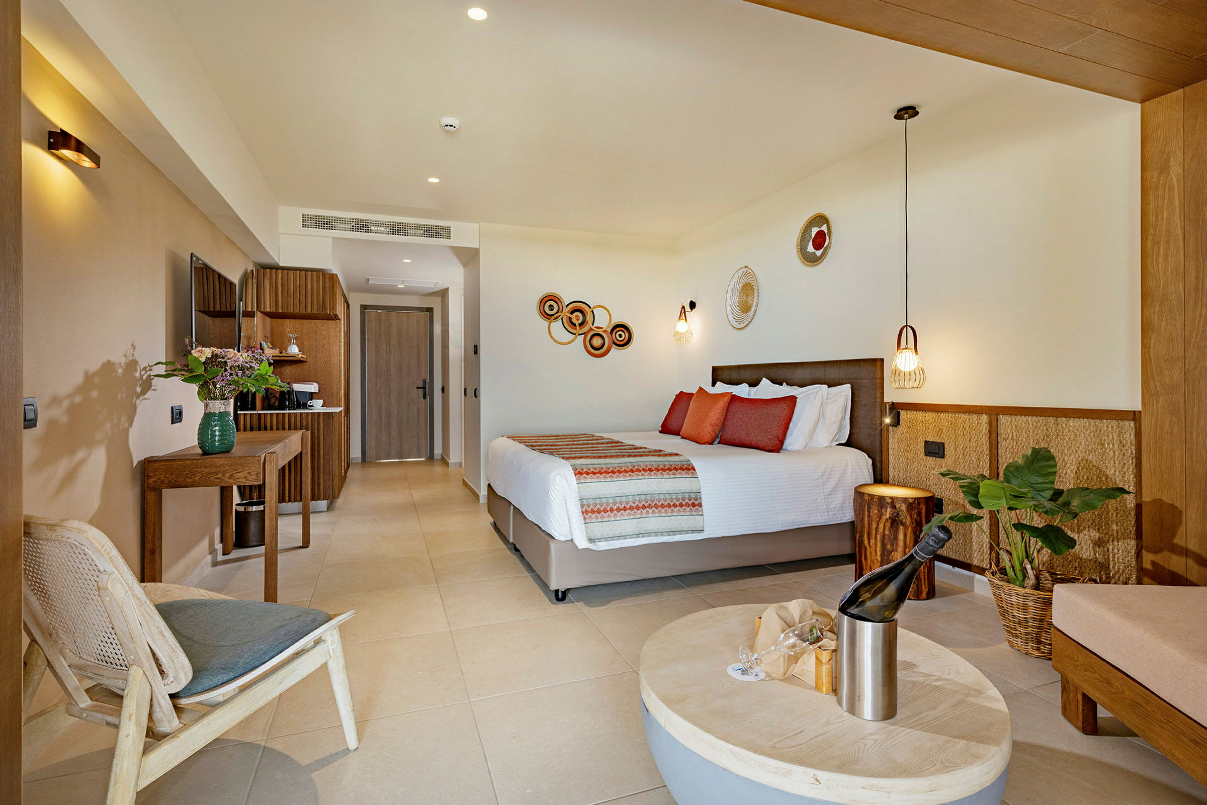 Modern hotellrum med dubbelsäng, dekorativa väggprydnader och sittmöbler. (AI-genererad text)