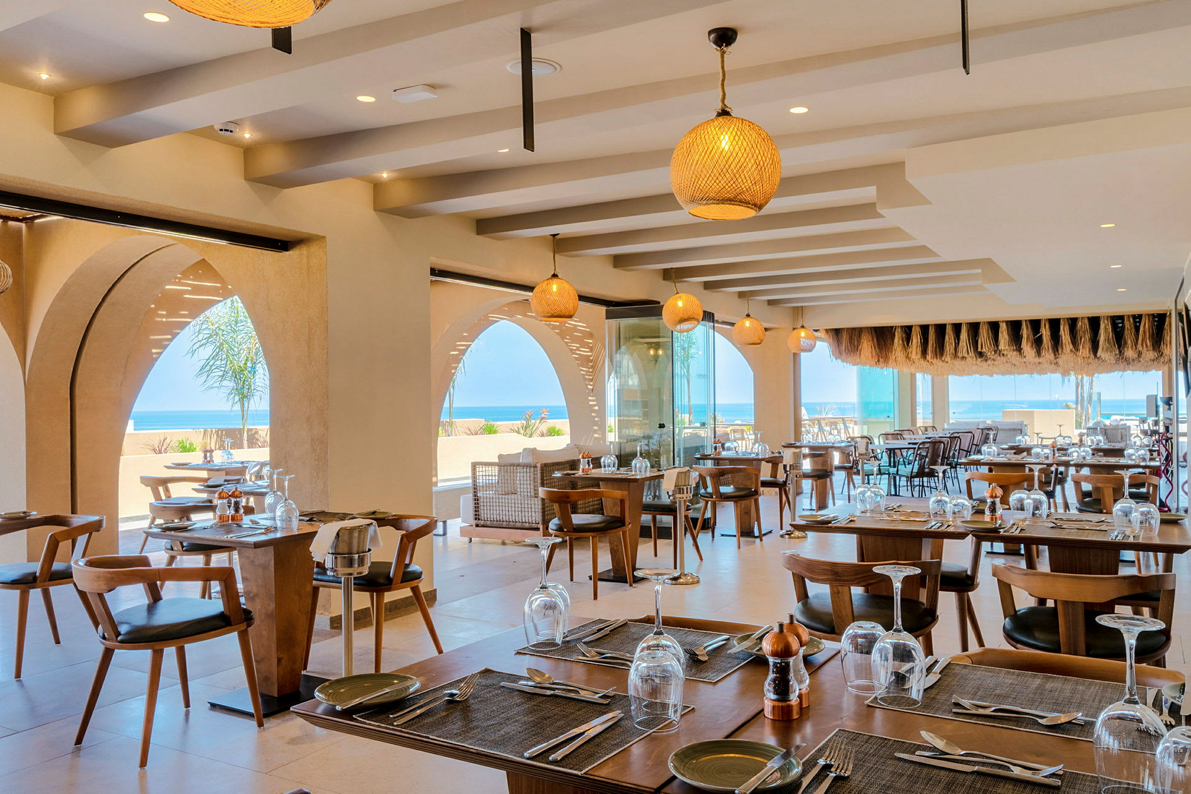 Restaurang med dukade bord och havsutsikt. (AI-genererad text)