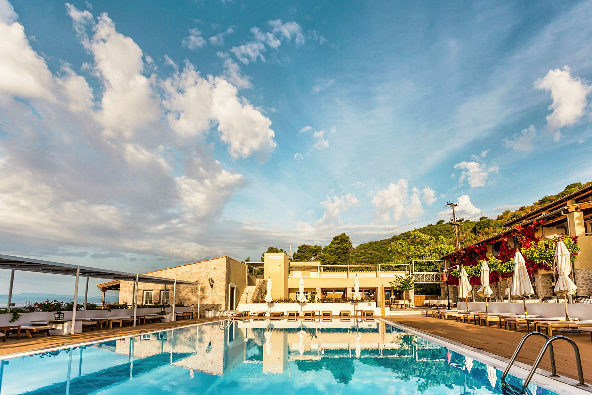 Utomhuspool vid ett hotell med berg i bakgrunden. (AI-genererad text)