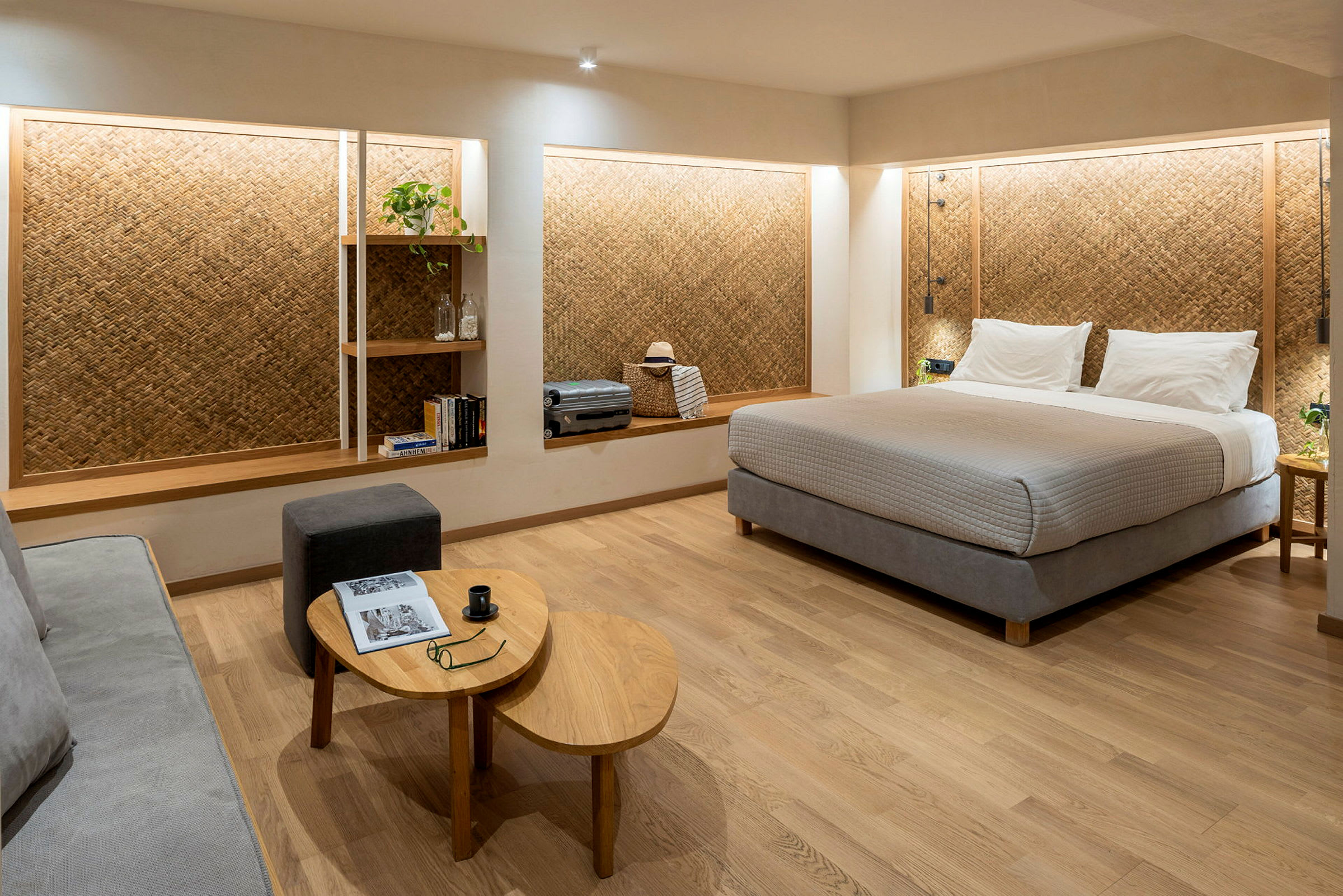 Ett hotellrum med en stor säng, en sittplats och hyllor på väggen. (AI-genererad text)