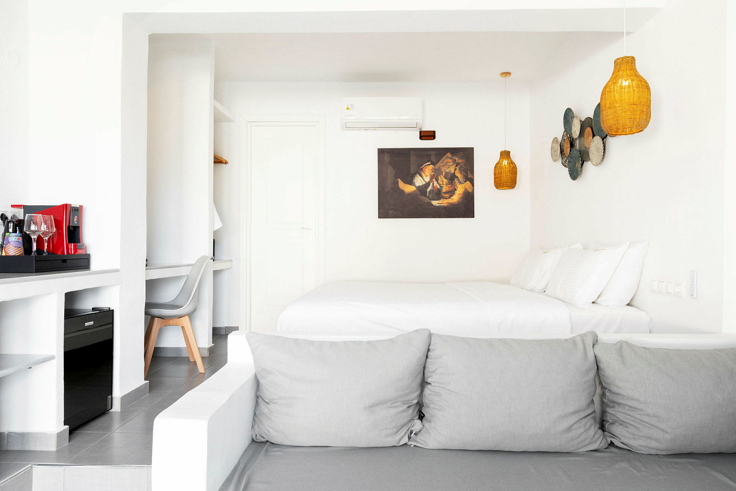 Ett hotellrum med en dubbelsäng, ljus inredning, och en kaffemaskin på en bänk. (AI-genererad text)