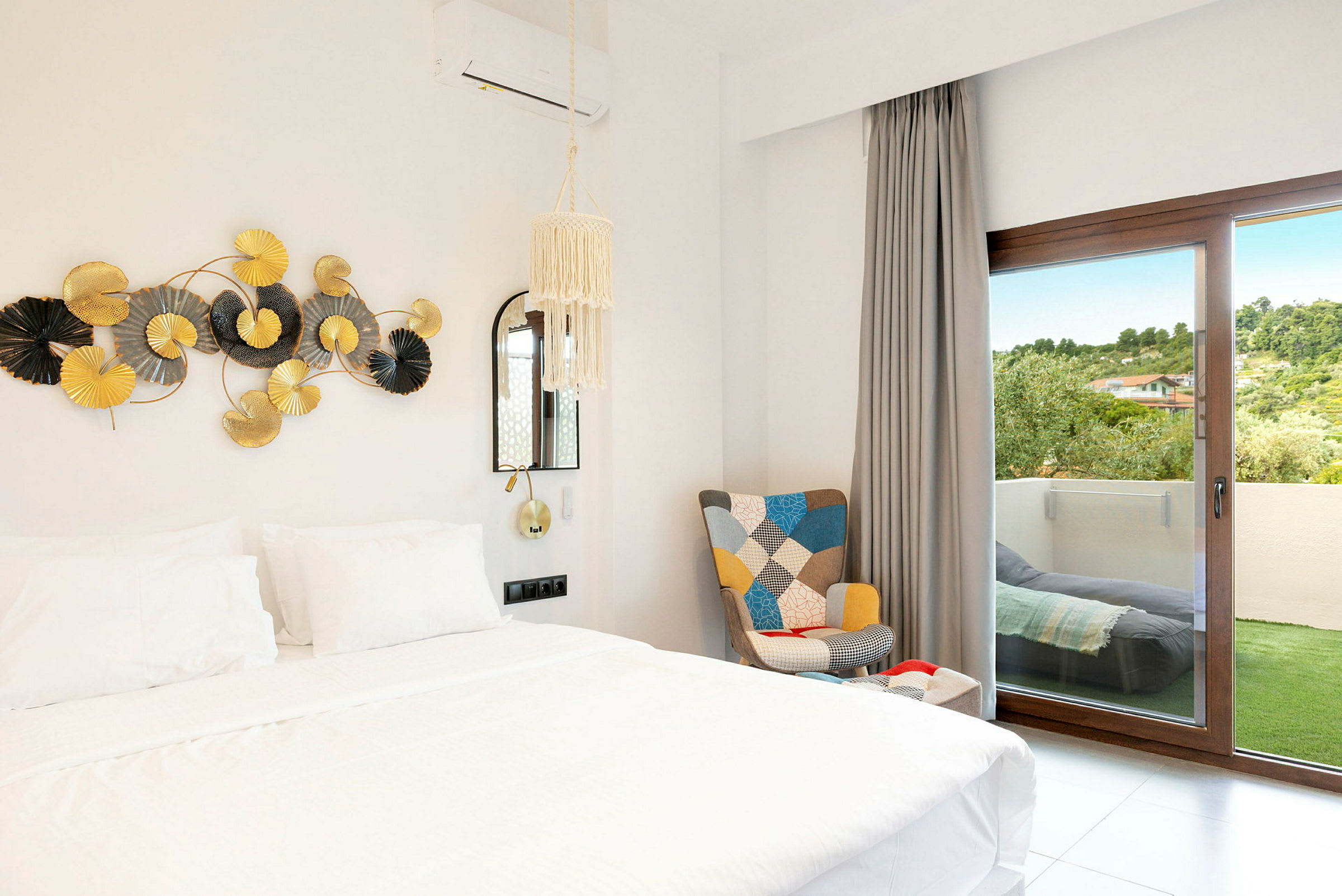 Bild på ett hotellrum med en vit säng, dekor på väggen och en dörr till en balkong. (AI-genererad text)