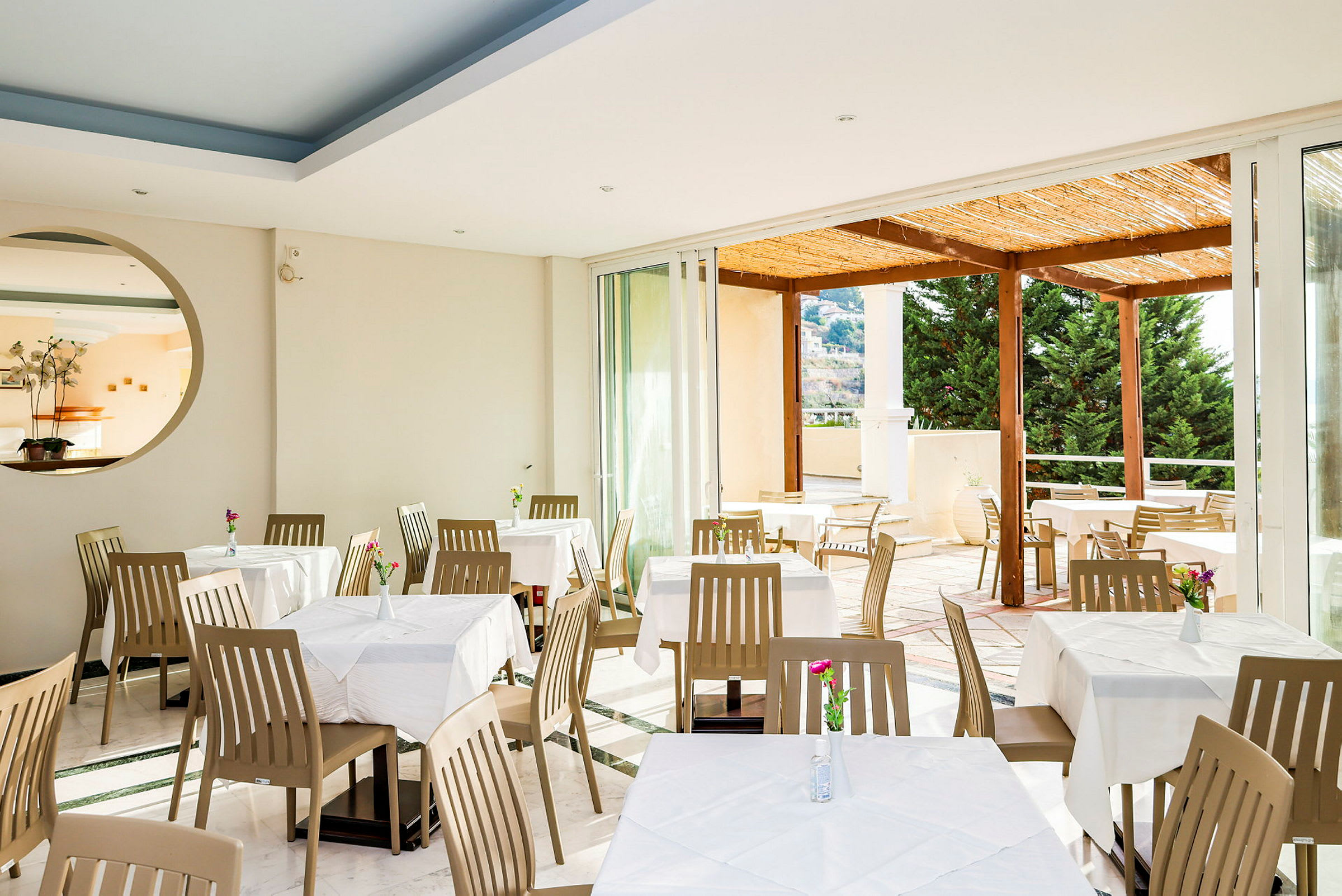 Restaurang med matbord och stolar, utsikt mot en terrass. (AI-genererad text)