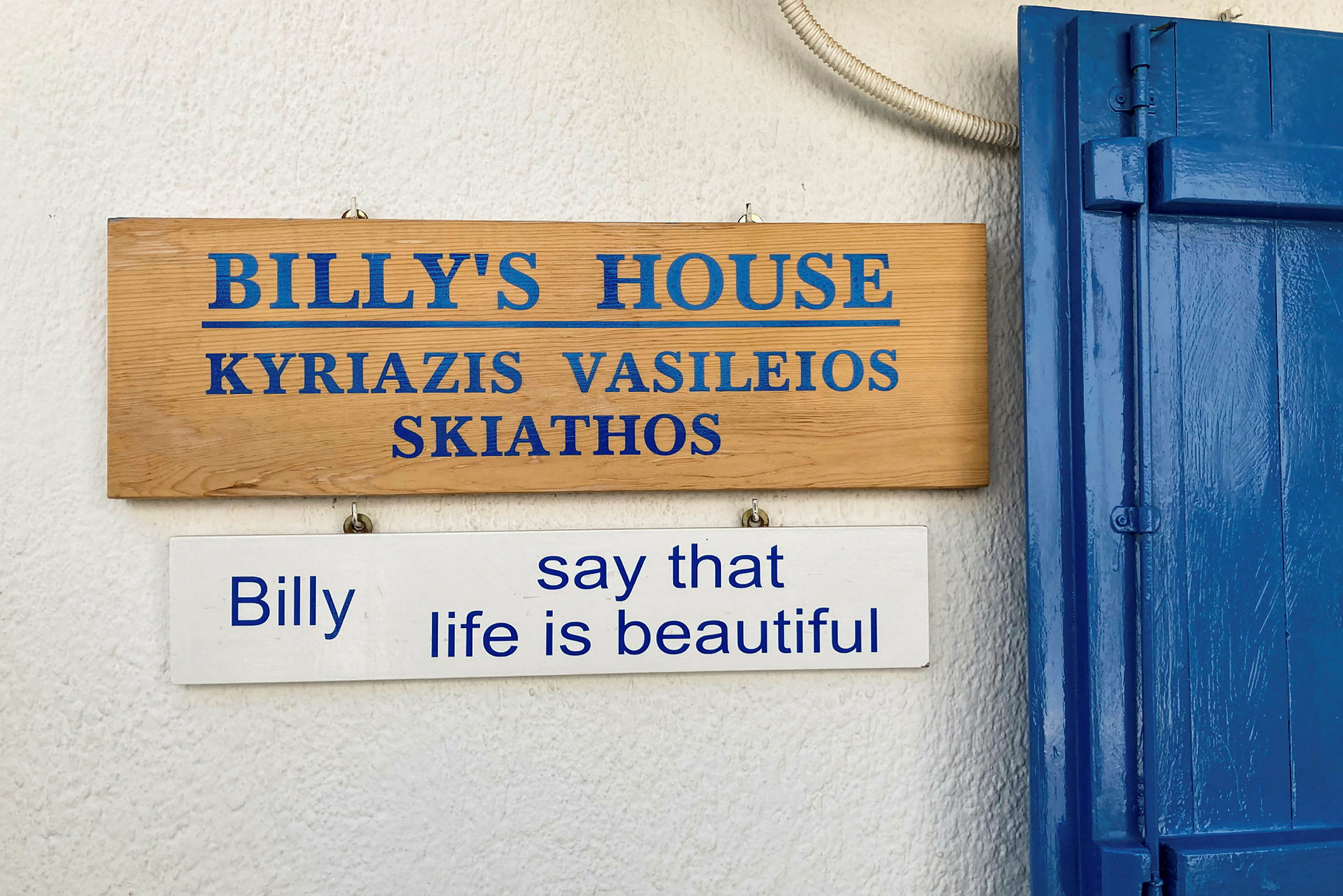 Träskylt som markerar 'Billy's House' och en vit skylt under som säger "Billy say that life is beautiful". (AI-genererad text)