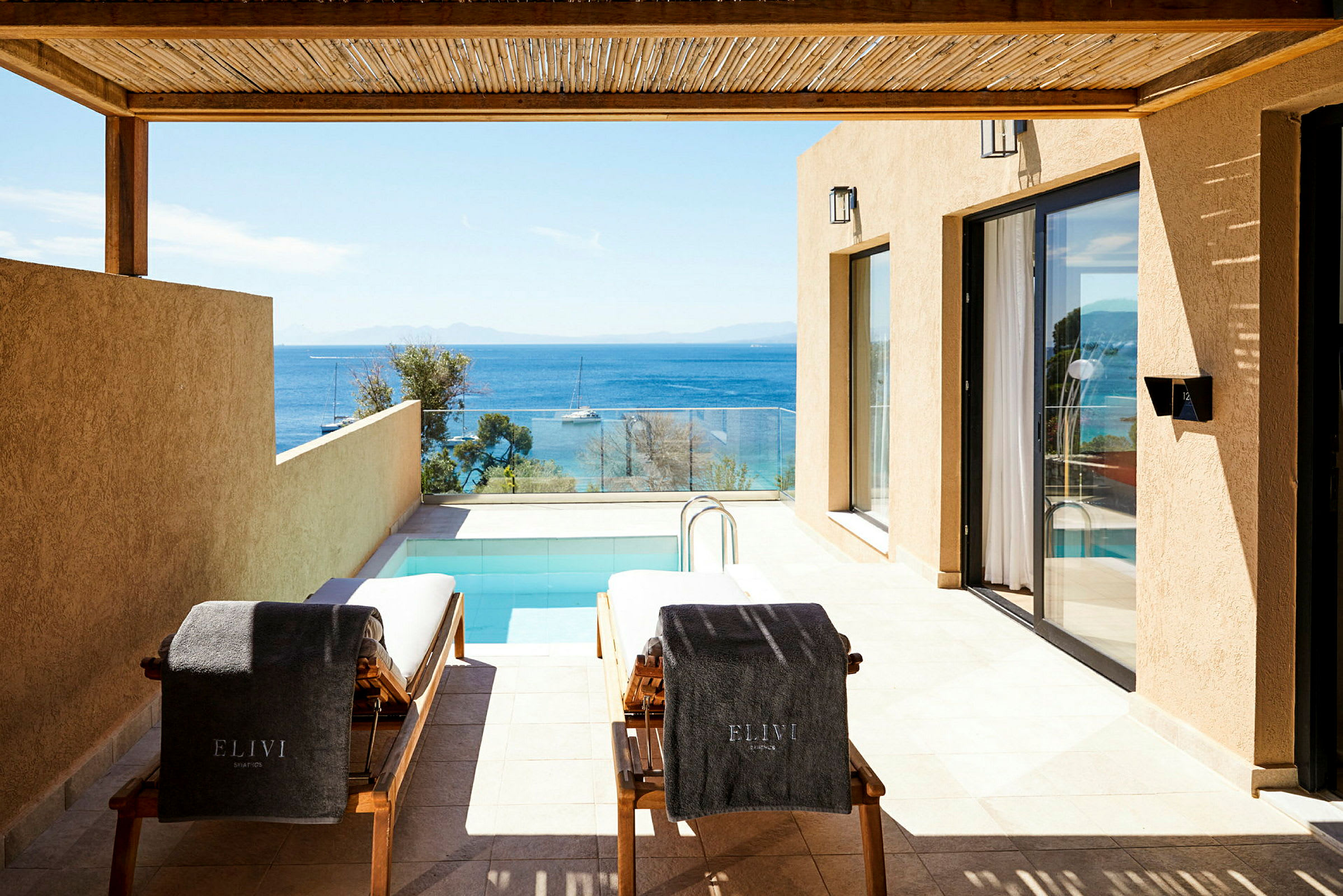 Två solstolar vid en privat pool, med utsikt över havet. (AI-genererad text)