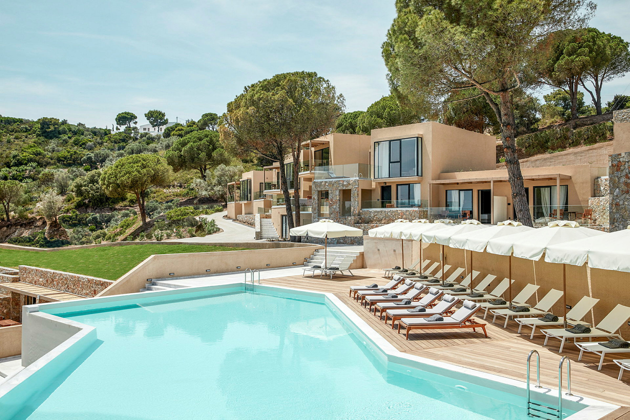 Poolområde vid en modern resort omgiven av grönskande natur. (AI-genererad text)