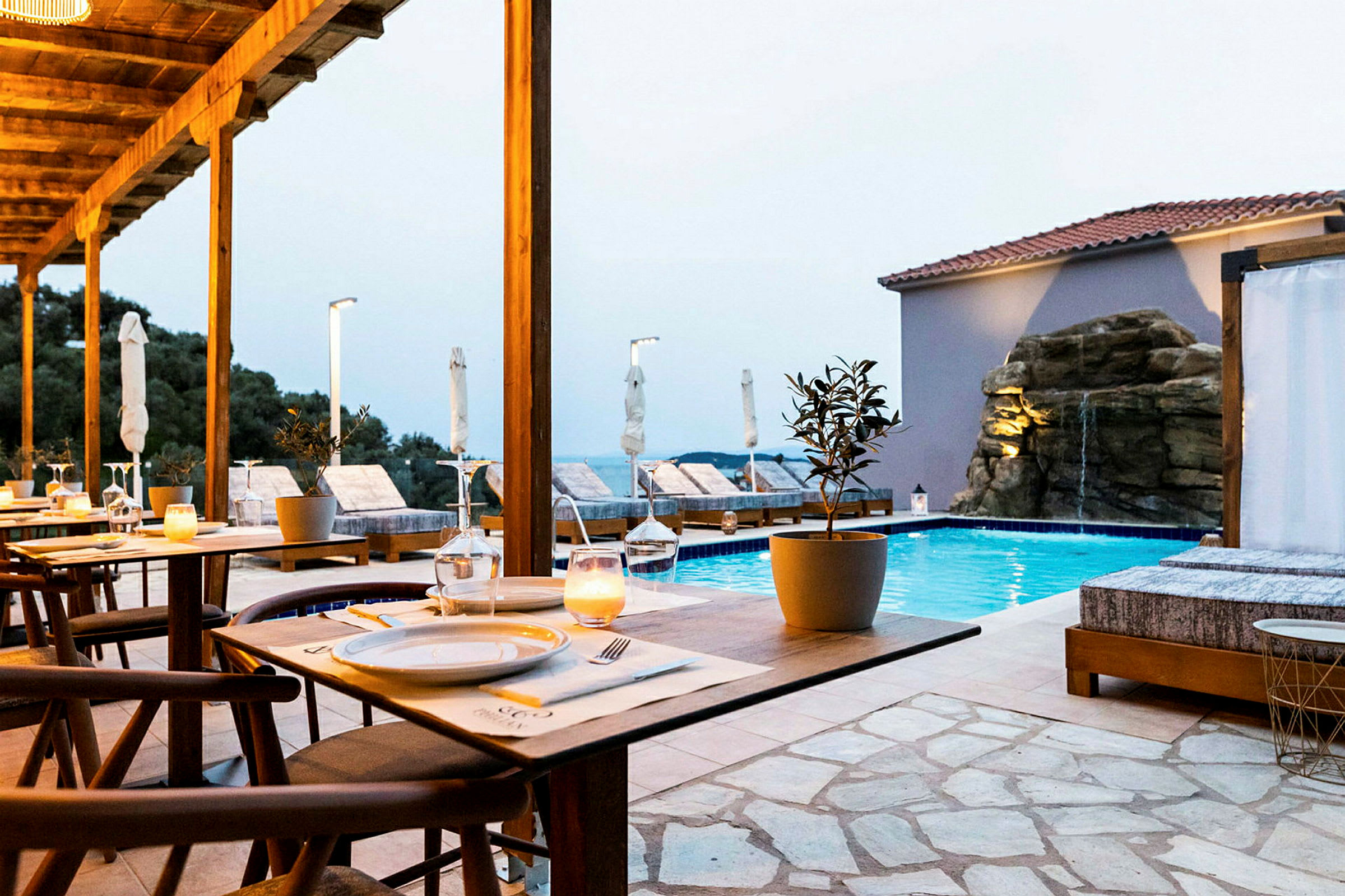 En restaurang med utsikt över en pool och solstolar. (AI-genererad text)