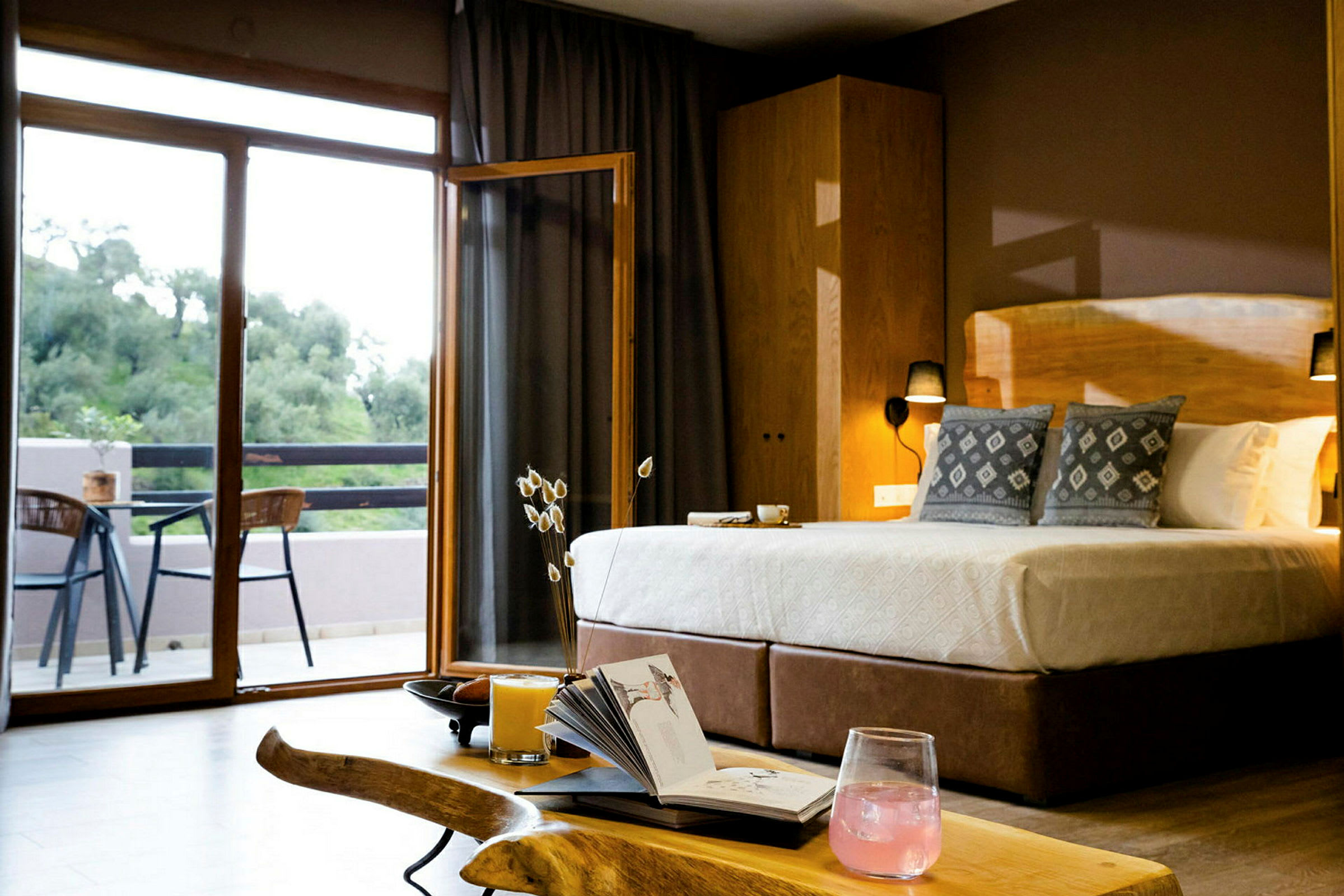 Hotellrum med dubbelsäng, sittgrupp och utgång till en balkong. (AI-genererad text)