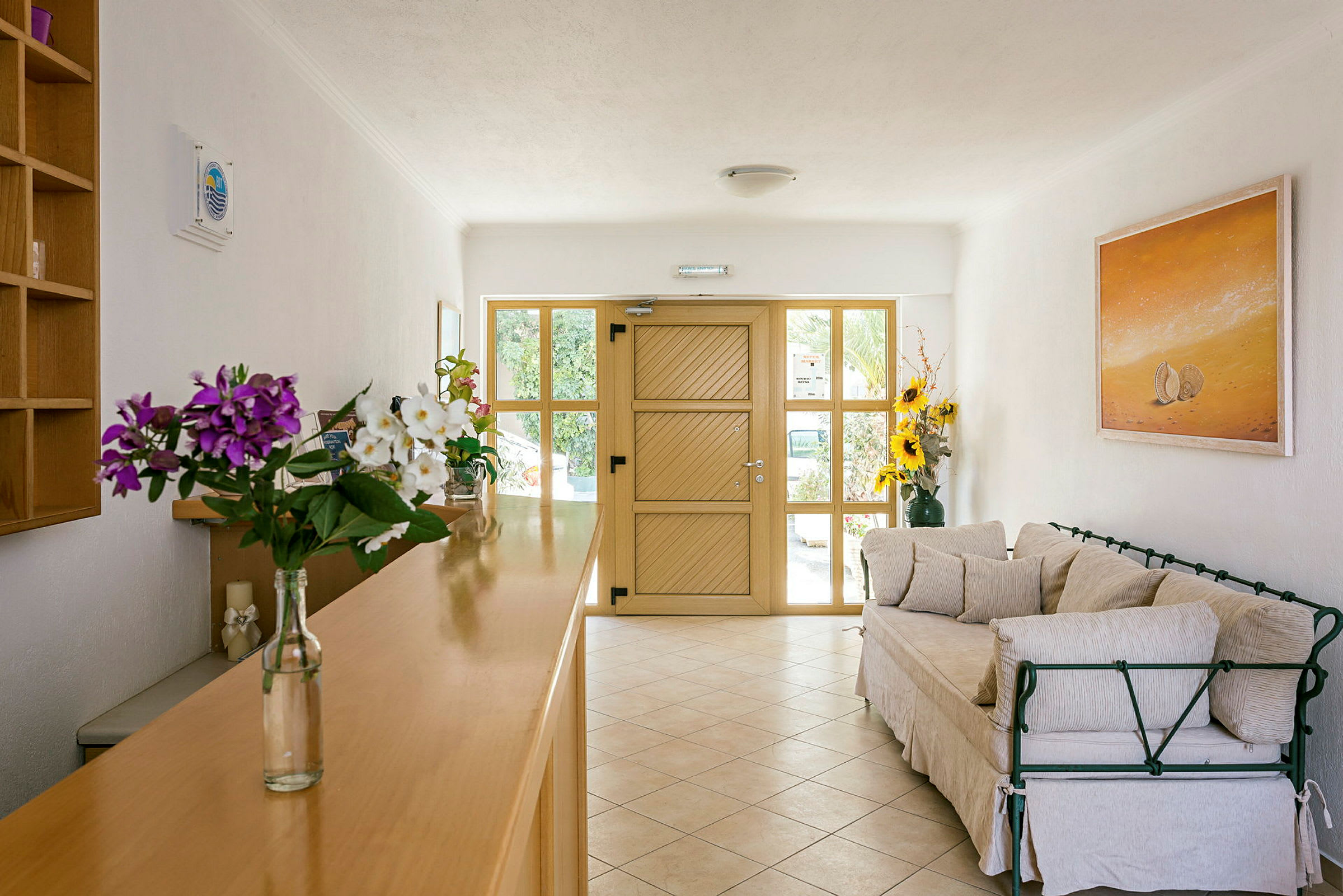 Entréhall med träinredd disk, soffa och blomsterdekorationer. (AI-genererad text)