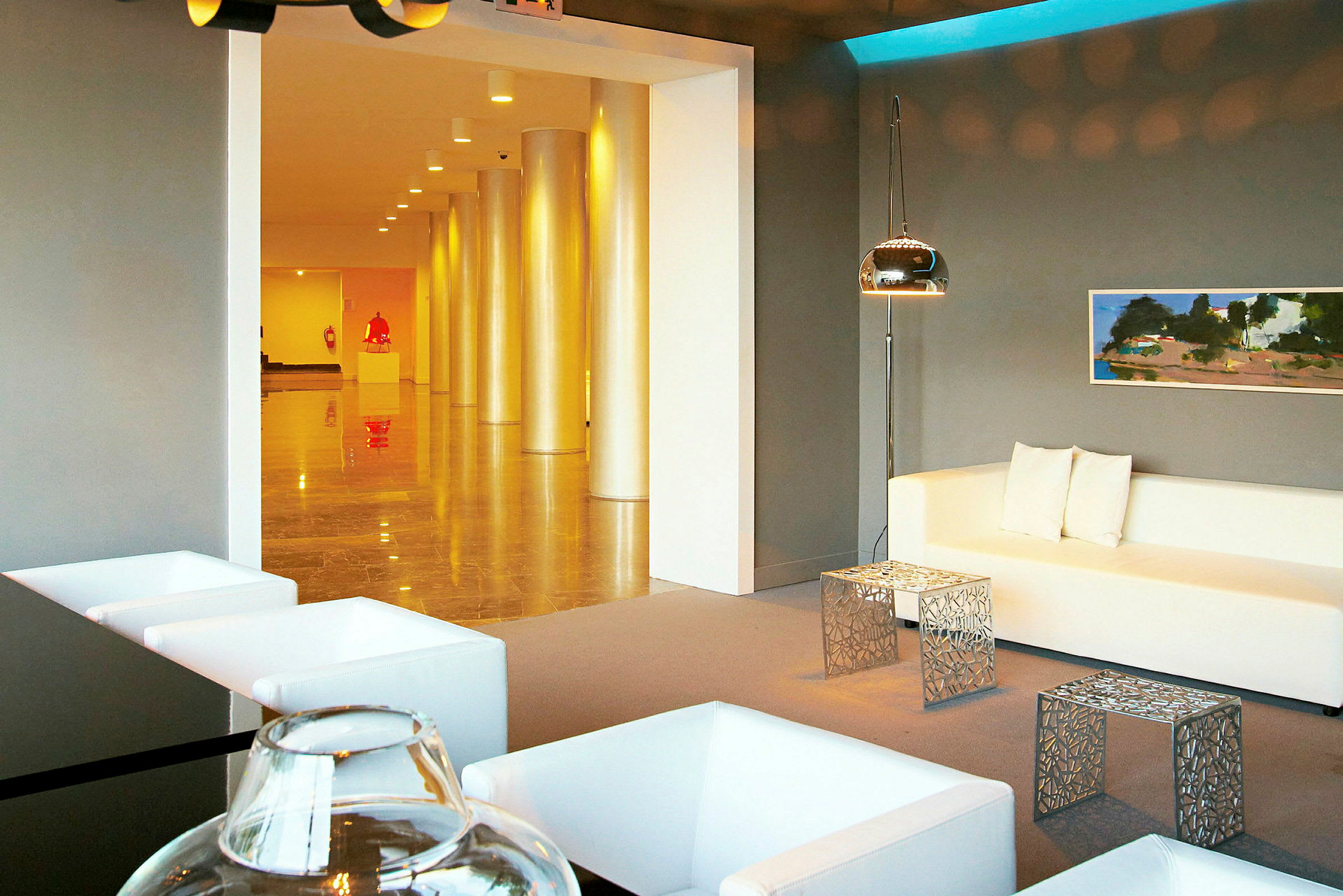 Modern hotellobby med vita möbler och konst i bakgrunden. (AI-genererad text)