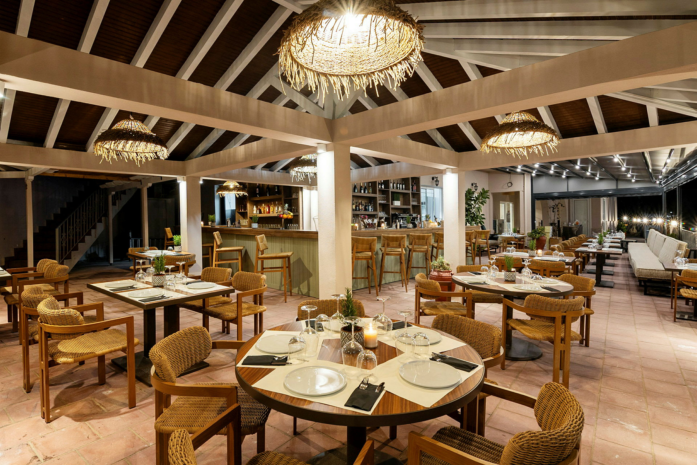 Restaurang med dukade bord, stolar och bar i bakgrunden. (AI-genererad text)
