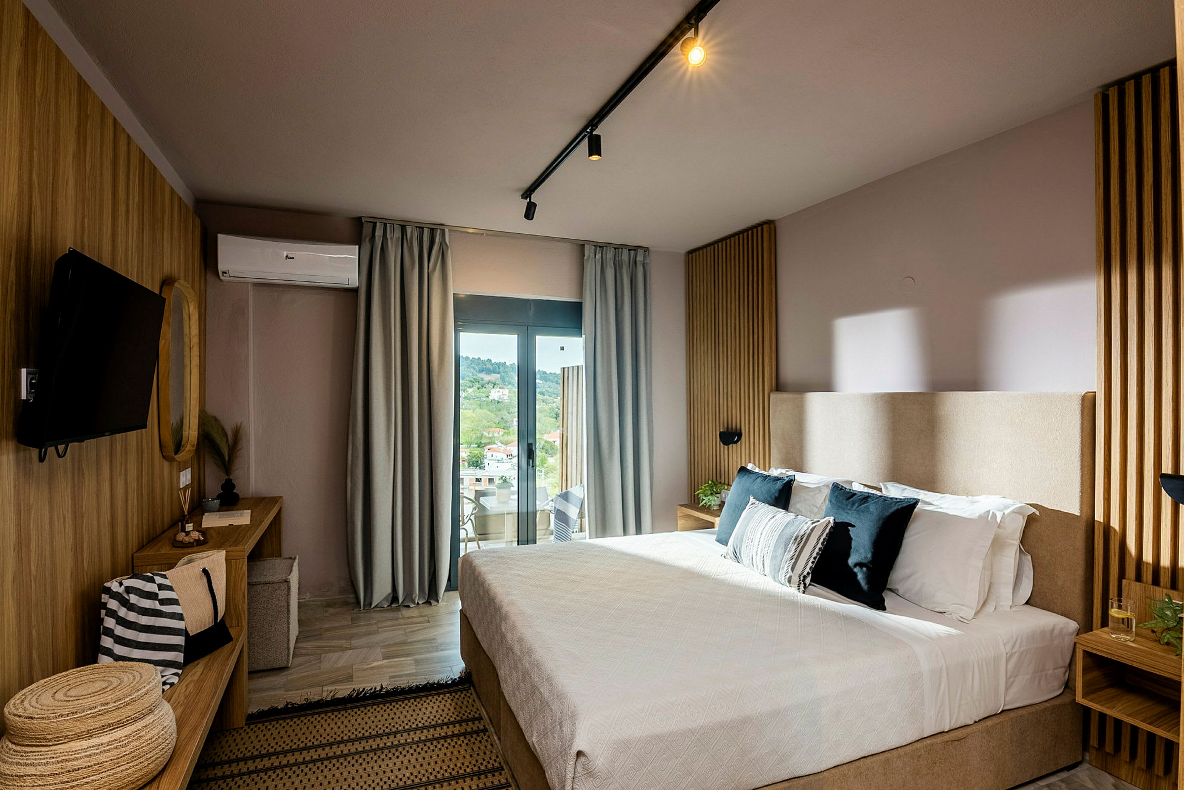 Ett modern hotellrum med säng, skrivbord och stor fönster med utsikt. (AI-genererad text)