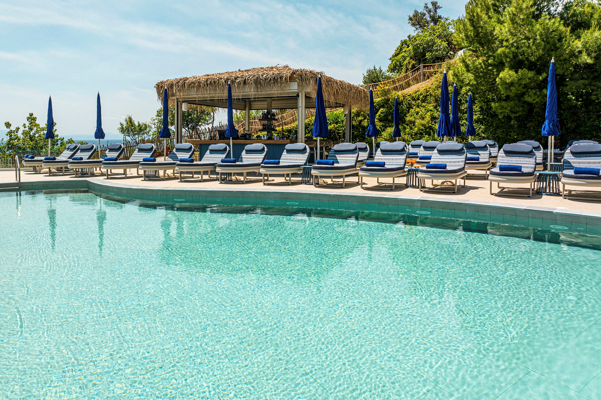 Pool med solstolar och parasoller. (AI-genererad text)