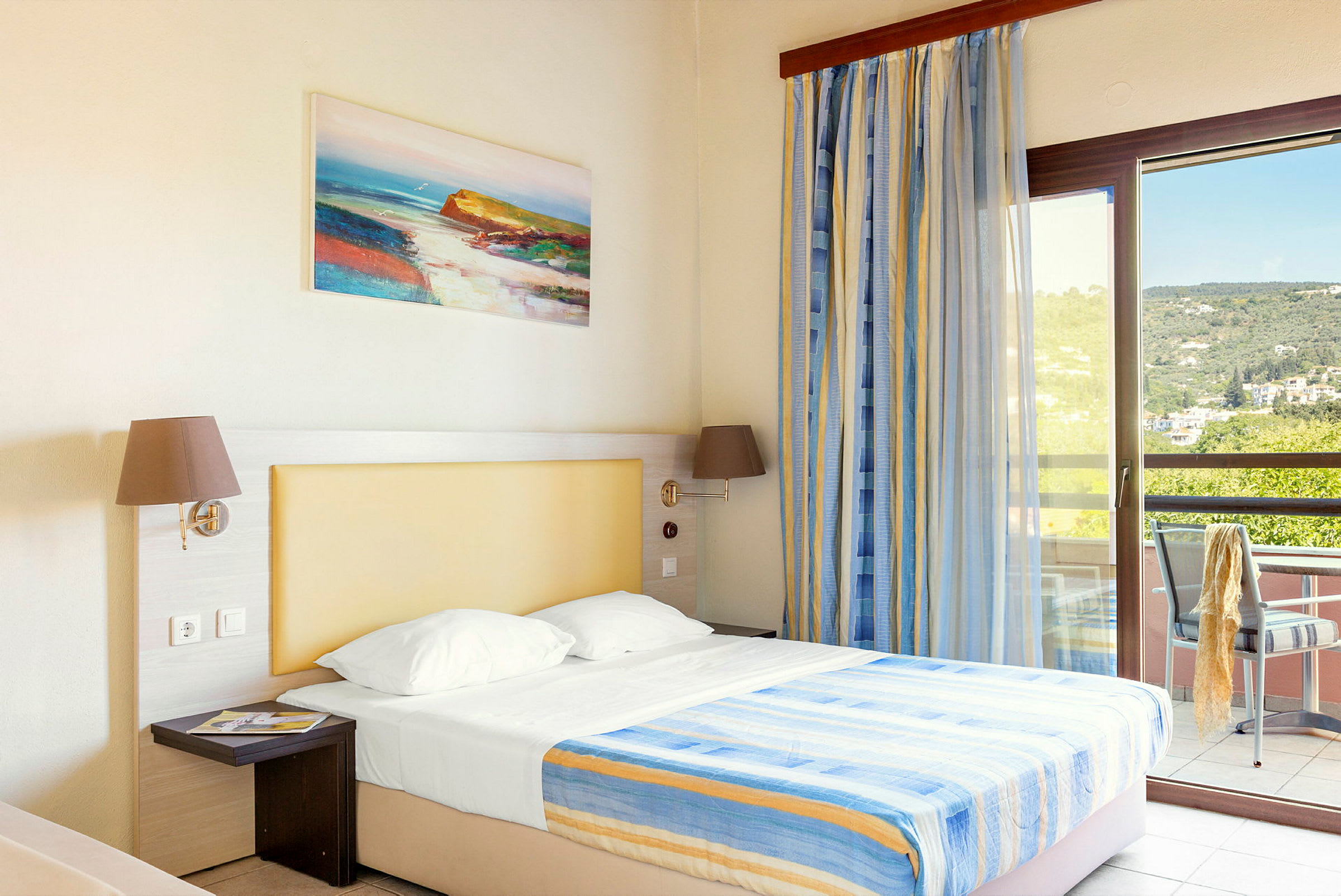 Ett hotellrum med en säng, upplyst med naturligt ljus från en balkong. (AI-genererad text)