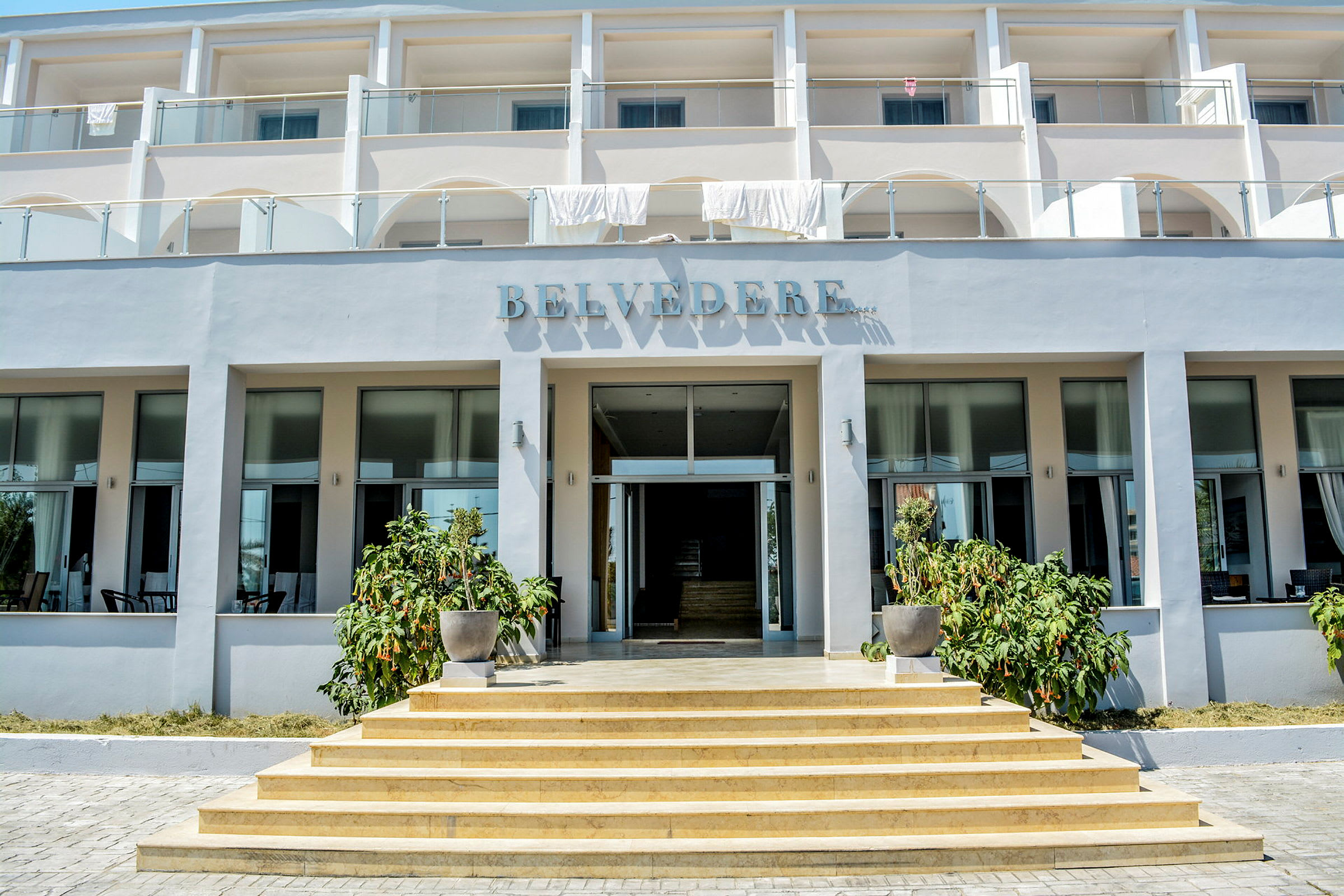 Hotellbyggnad med tre våningar, namnet 'Belvedere' synligt ovanför ingången. (AI-genererad text)