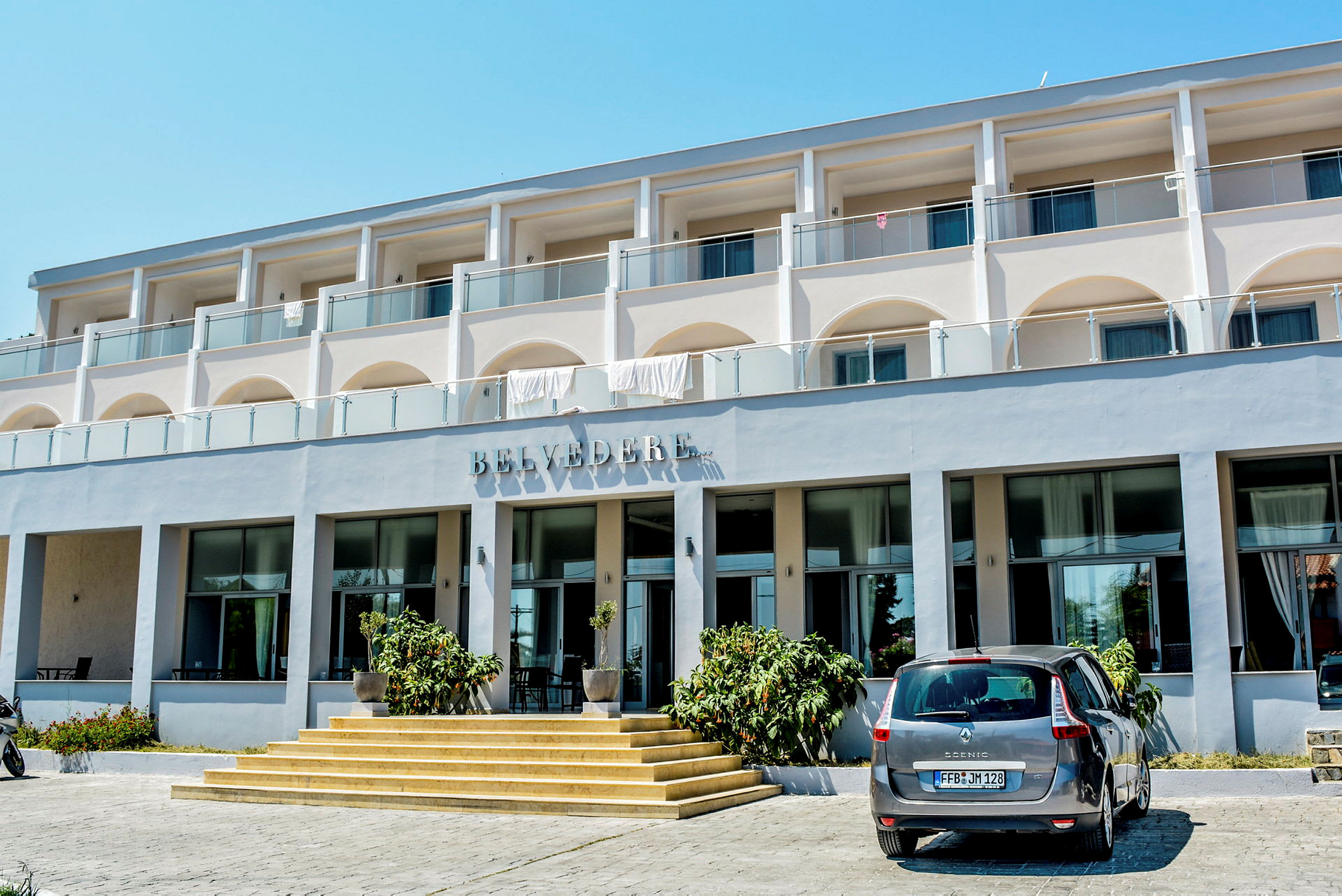 Exteriör av hotellbyggnaden Belvedere med bil parkerad framför entrén. (AI-genererad text)