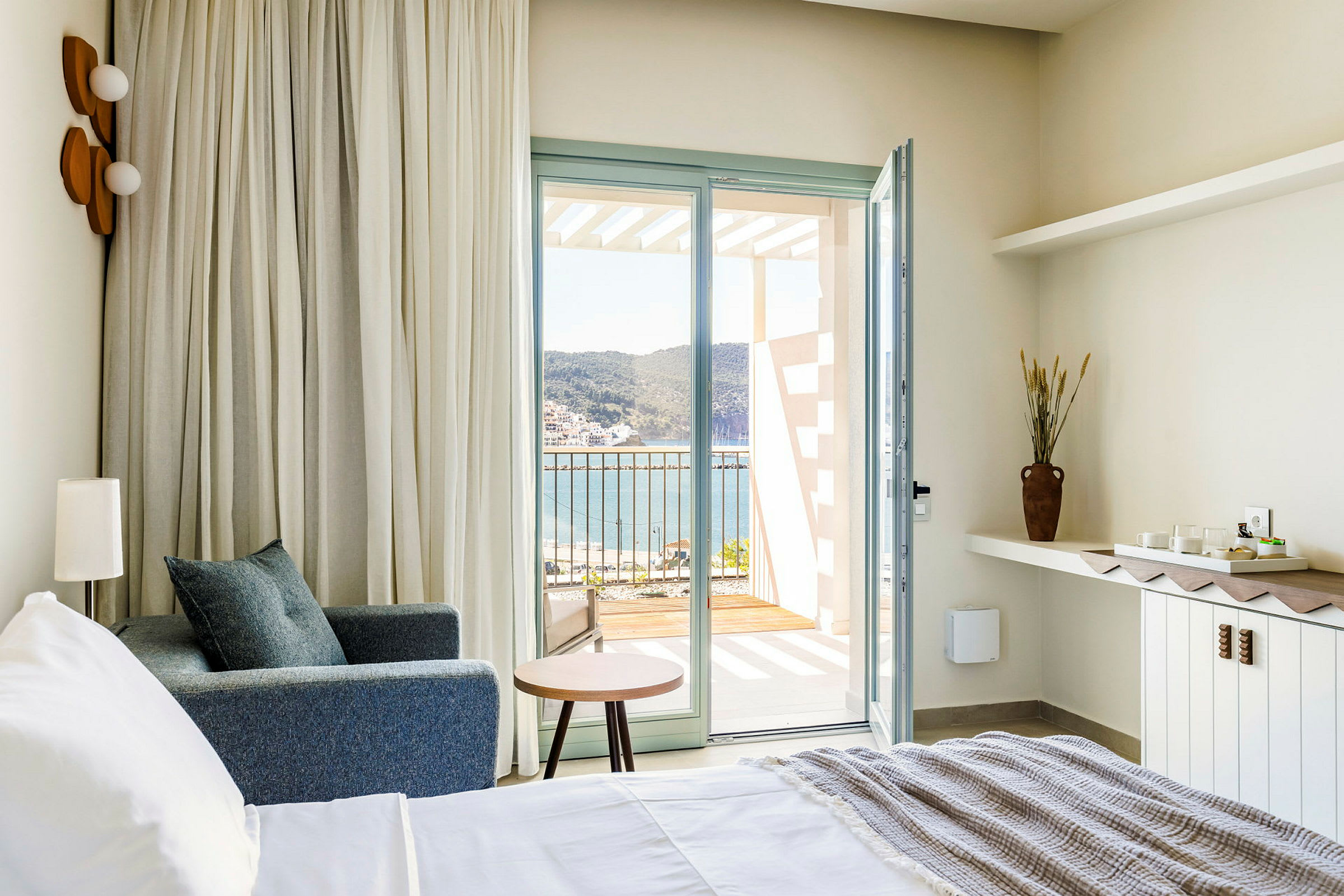 Hotellrum med utsikt över havet från en öppen balkongdörr. (AI-genererad text)