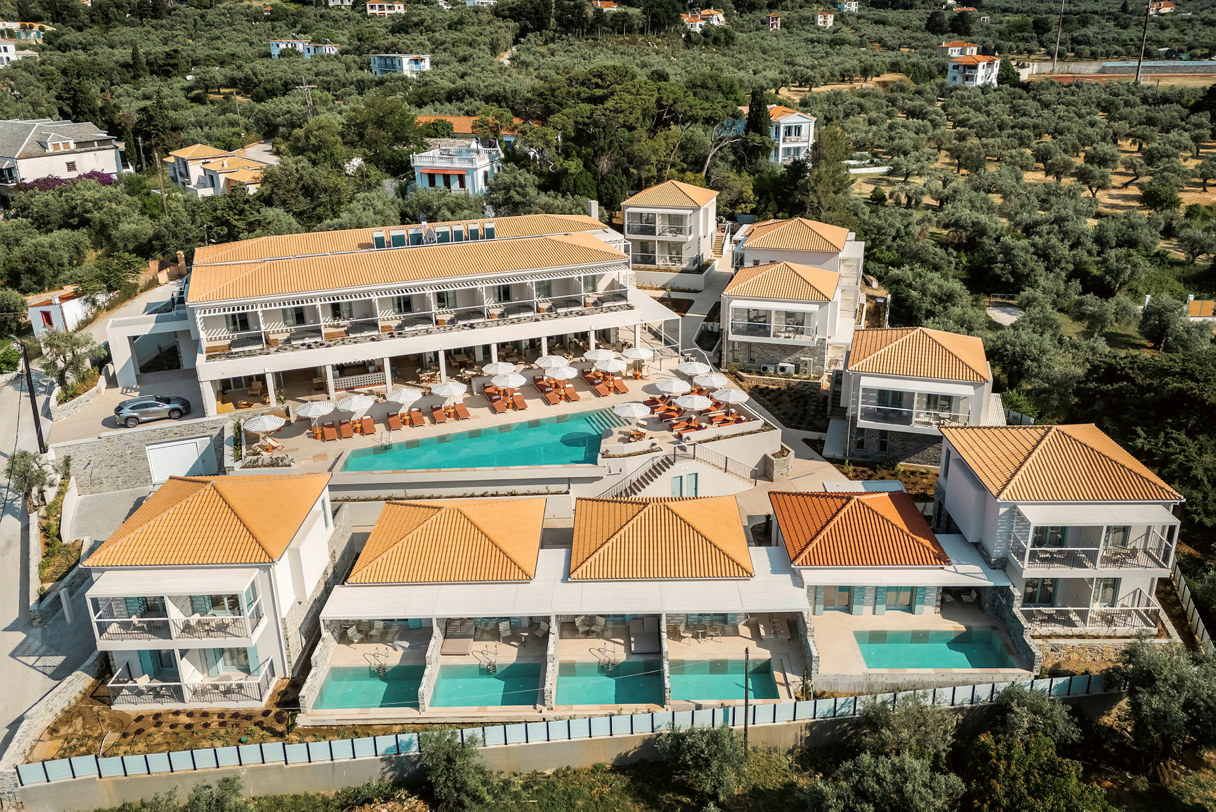 Hotellanläggning med pool och solstolar, omgiven av grönska. (AI-genererad text)