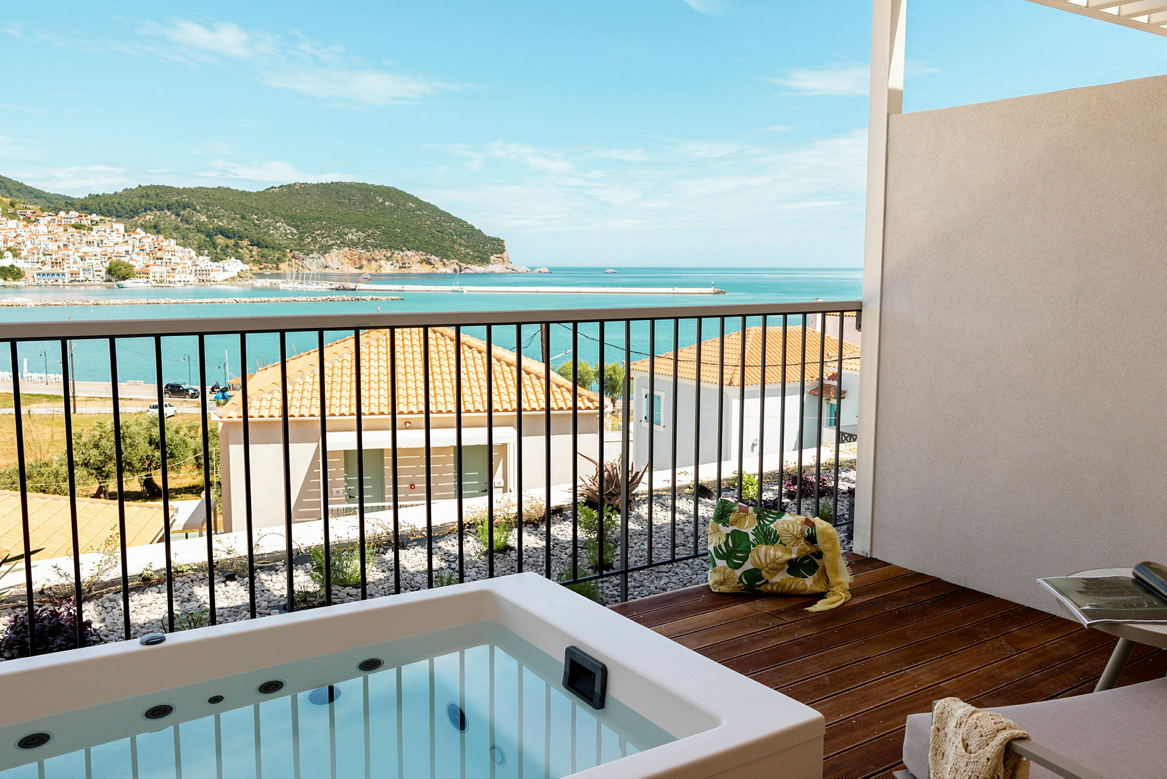 Utsikt från balkong med jacuzzi över bostadshus och hav i bakgrunden. (AI-genererad text)