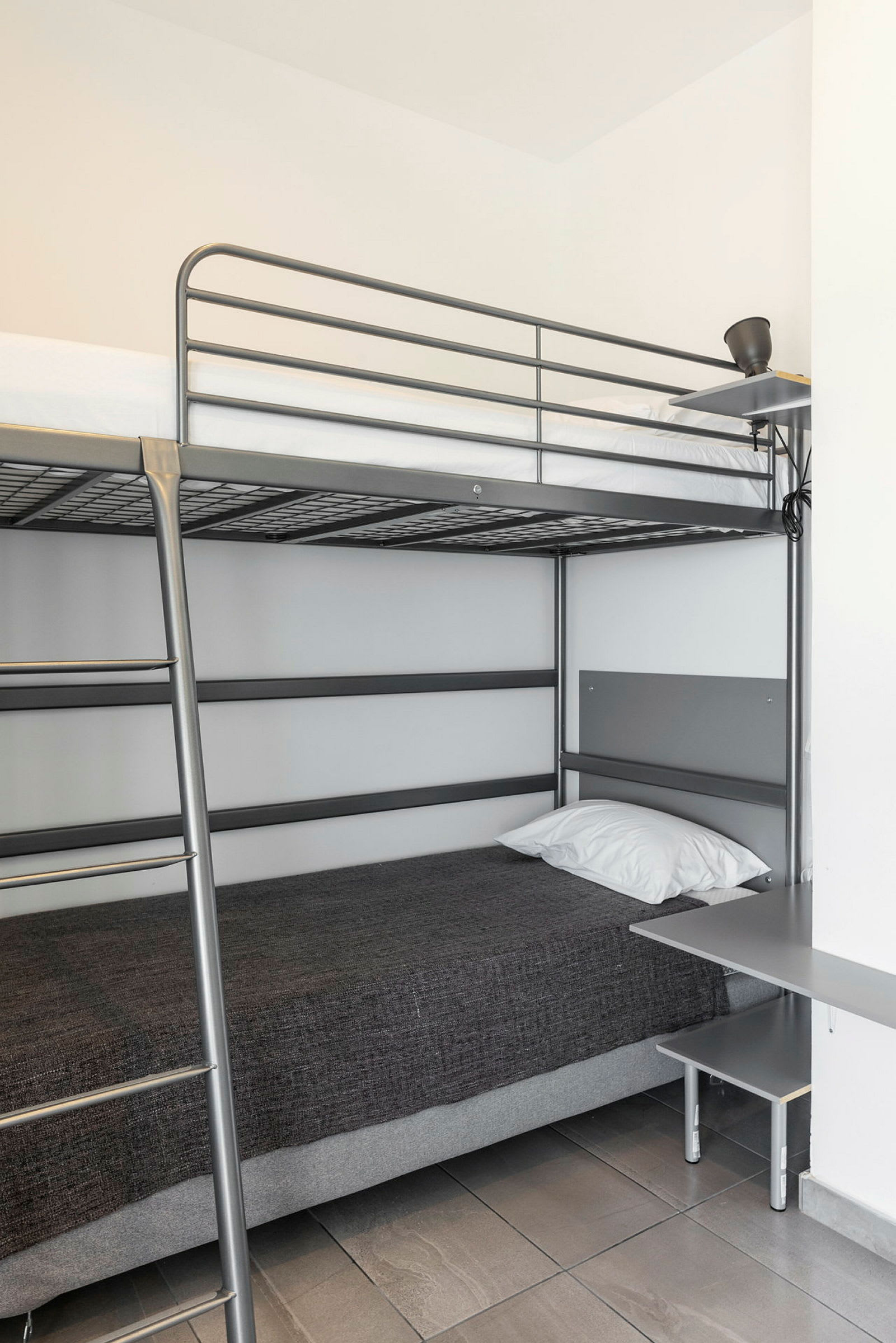 Våningssäng med metallram i ett rum. (AI-genererad text)
