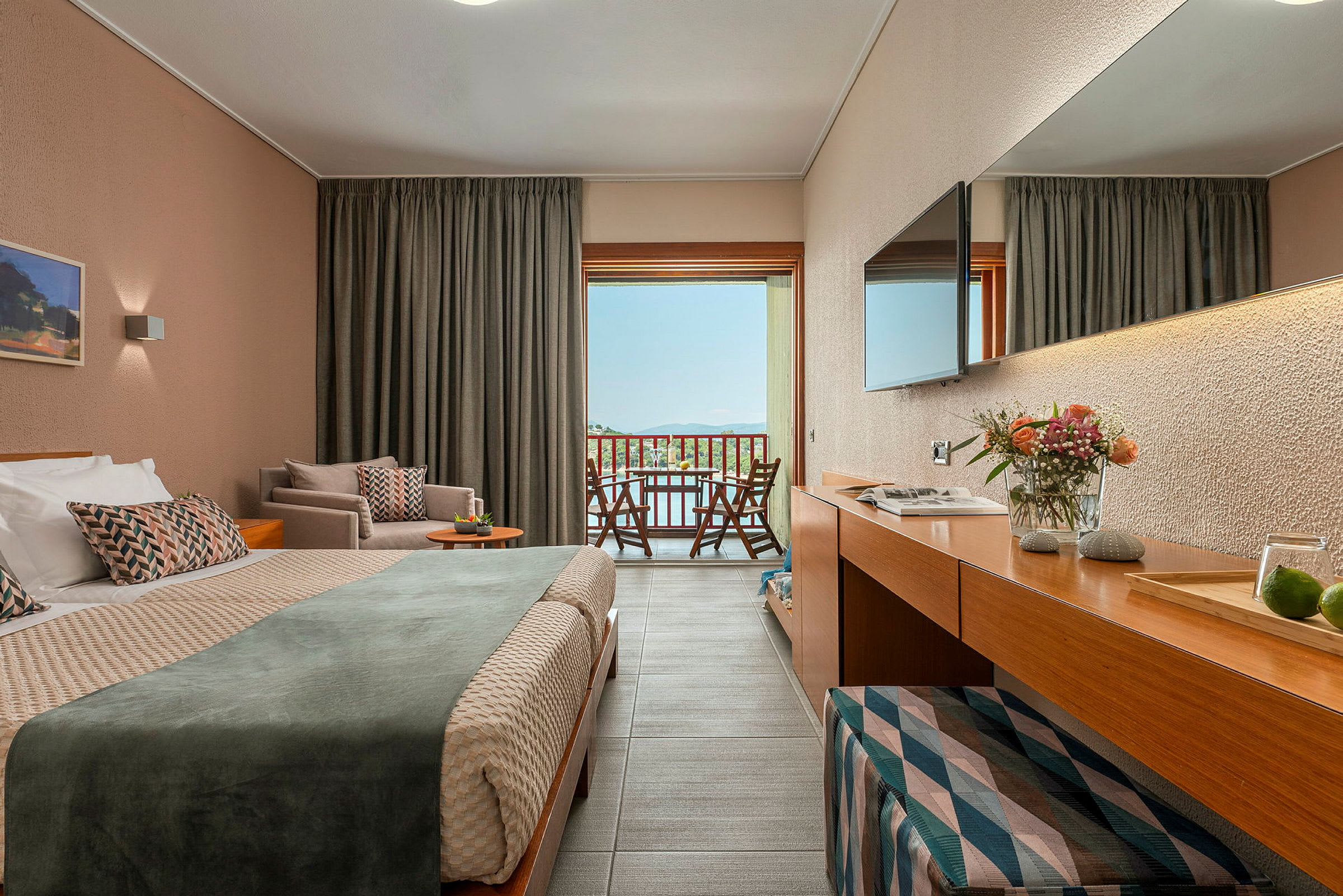 En hotellrum med dubbelsäng och balkongutsikt över landskap. (AI-genererad text)