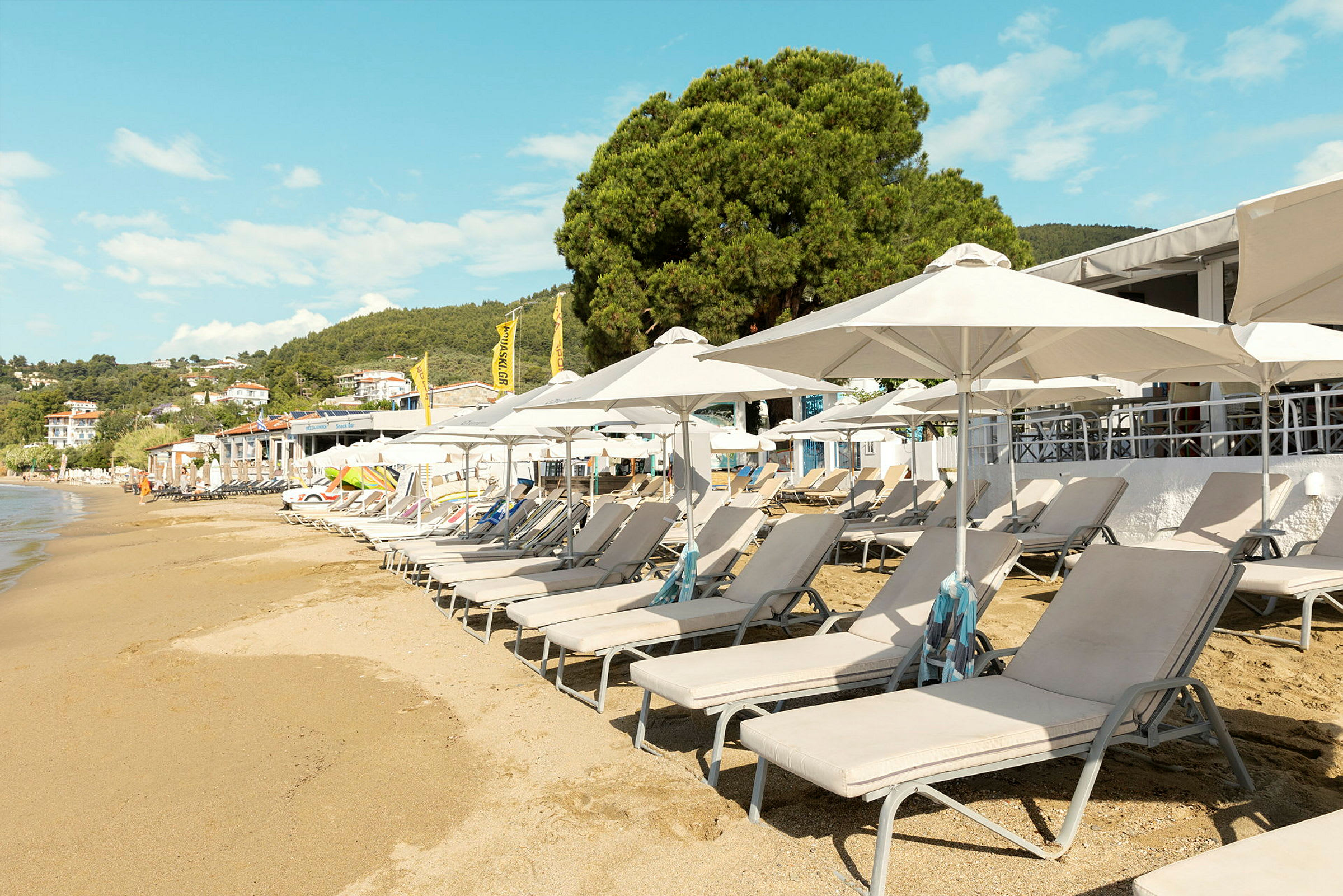 Solstolar och parasoller vid en sandstrand. (AI-genererad text)