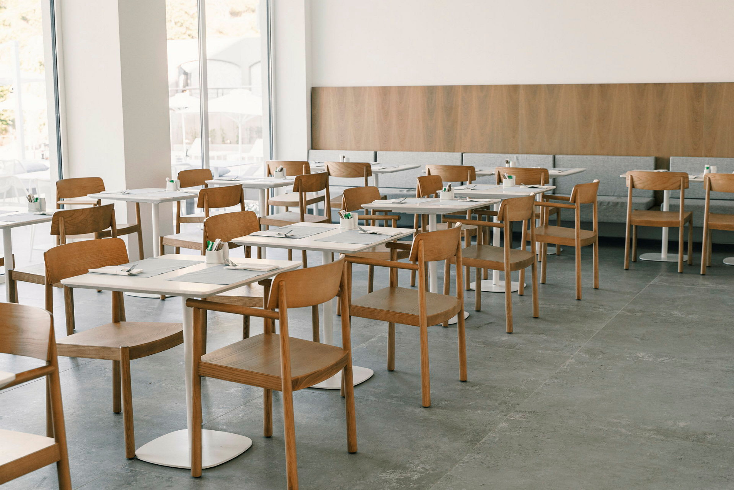 Restaurang med moderna trästolar och dukade bord. (AI-genererad text)