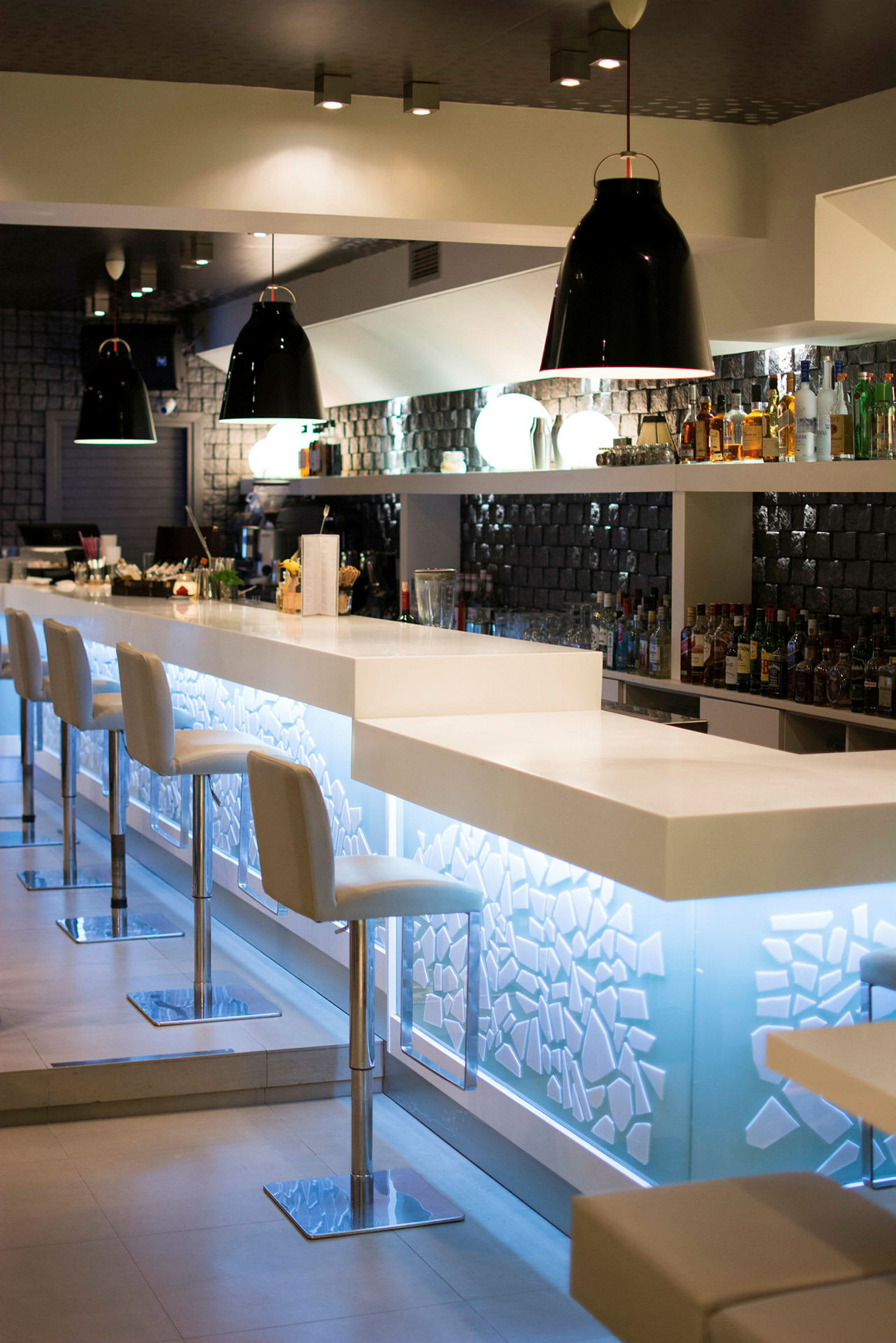 En modern bar med vita stolar och en ljussatt bardisk. (AI-genererad text)