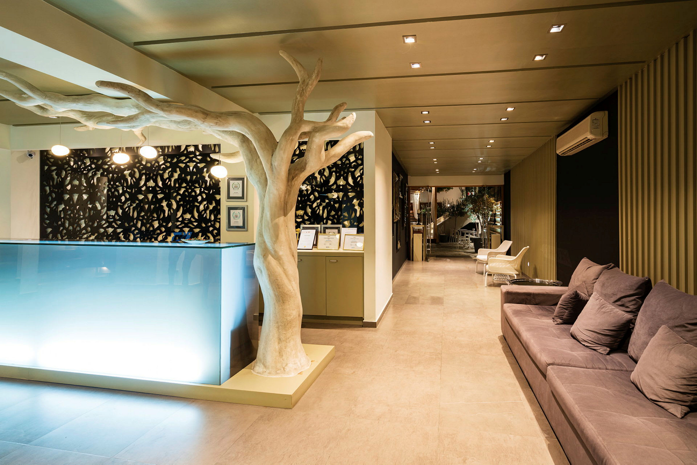 Hotellreception med modern inredning, soffor och ett dekorerat träformad objekt. (AI-genererad text)