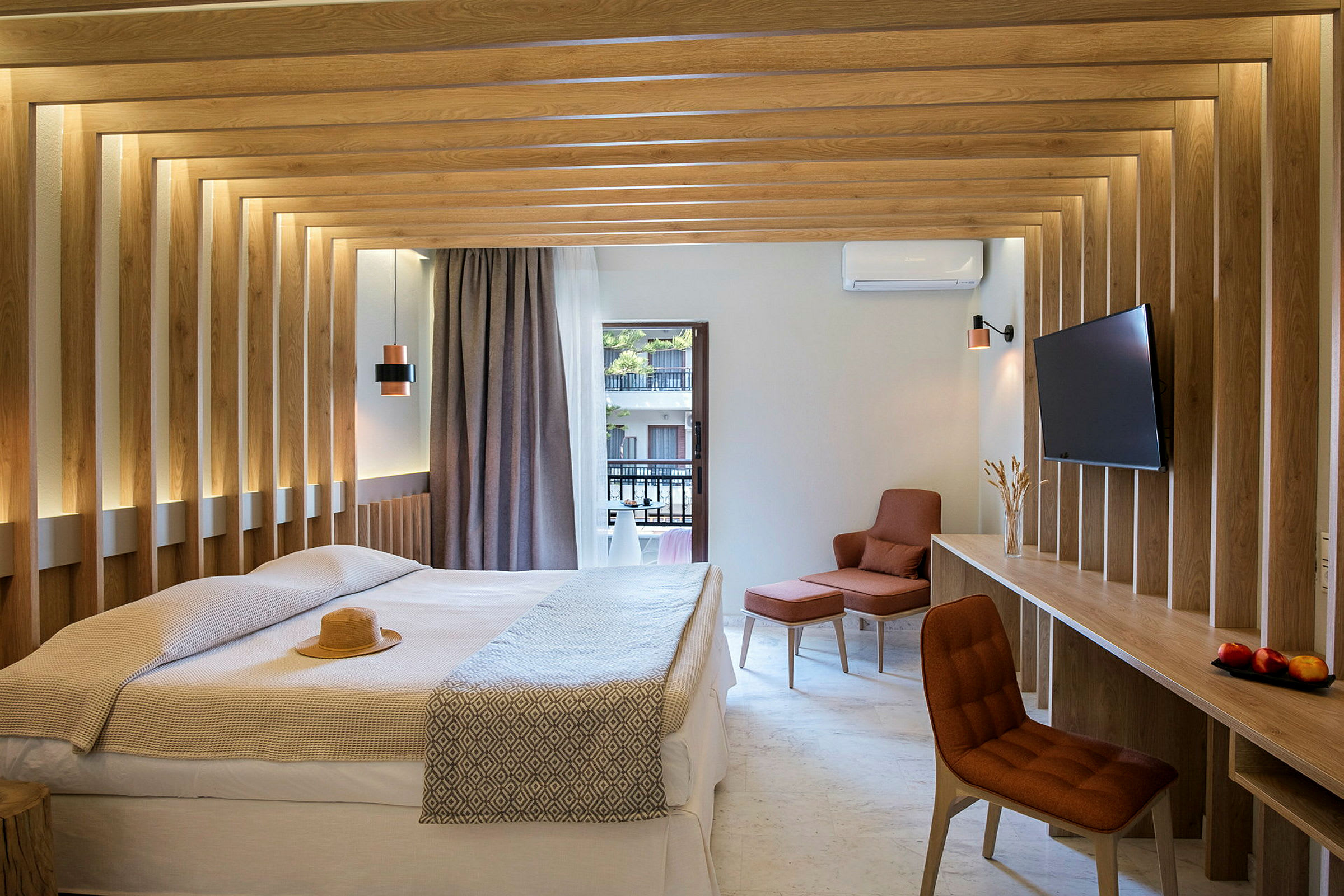 Ett modernt hotellrum med en dubbelsäng, träpaneler på väggarna, och utsikt mot en balkong. Rummet har en tv och en bekväm sittplats. (AI-genererad text)