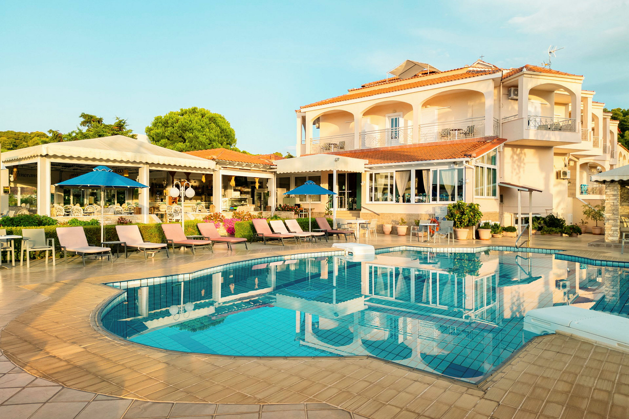Hotell med pool och solsängar. (AI-genererad text)