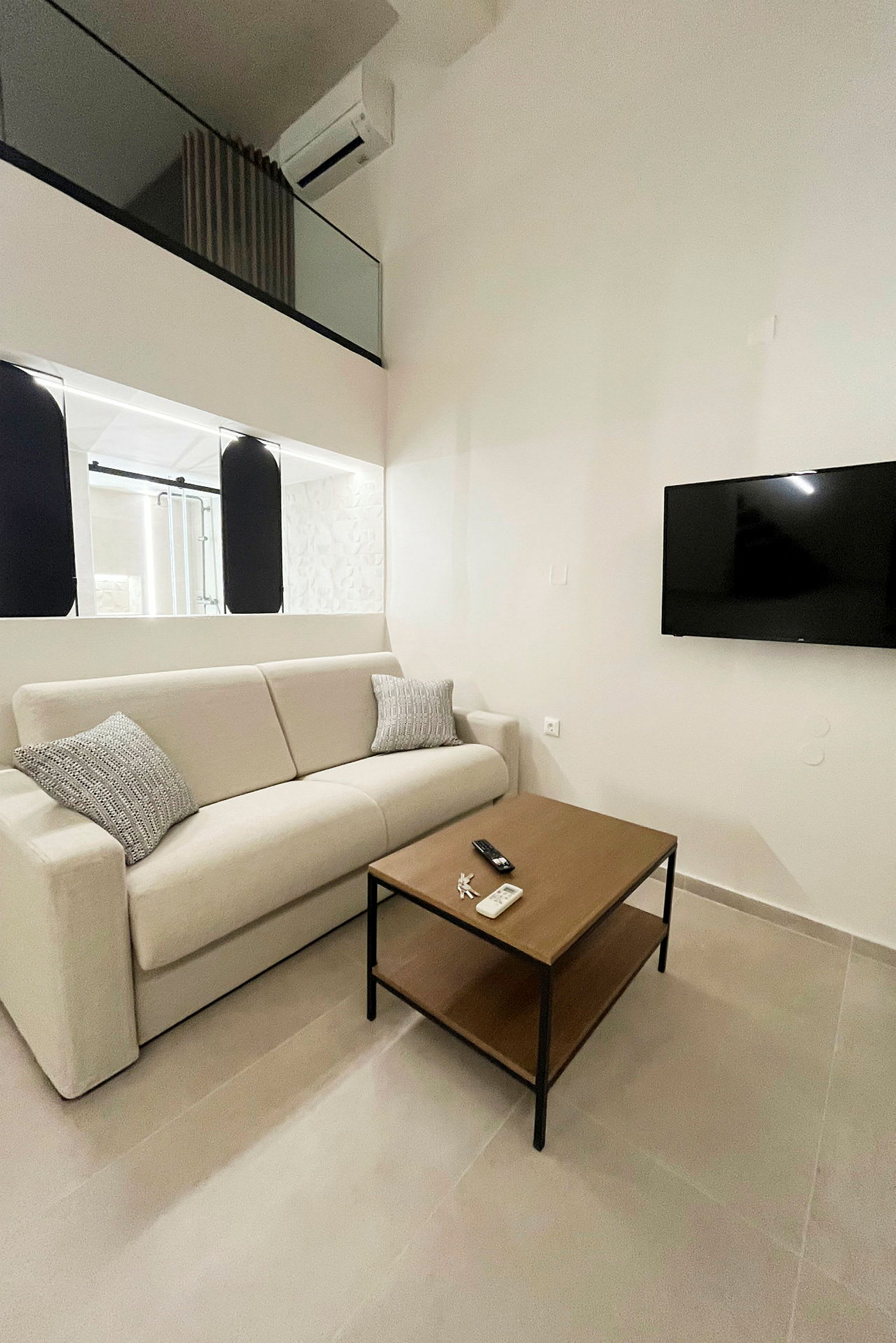 Bild av ett modernt rum med en beige soffa, en träbord och en väggmonterad TV. (AI-genererad text)