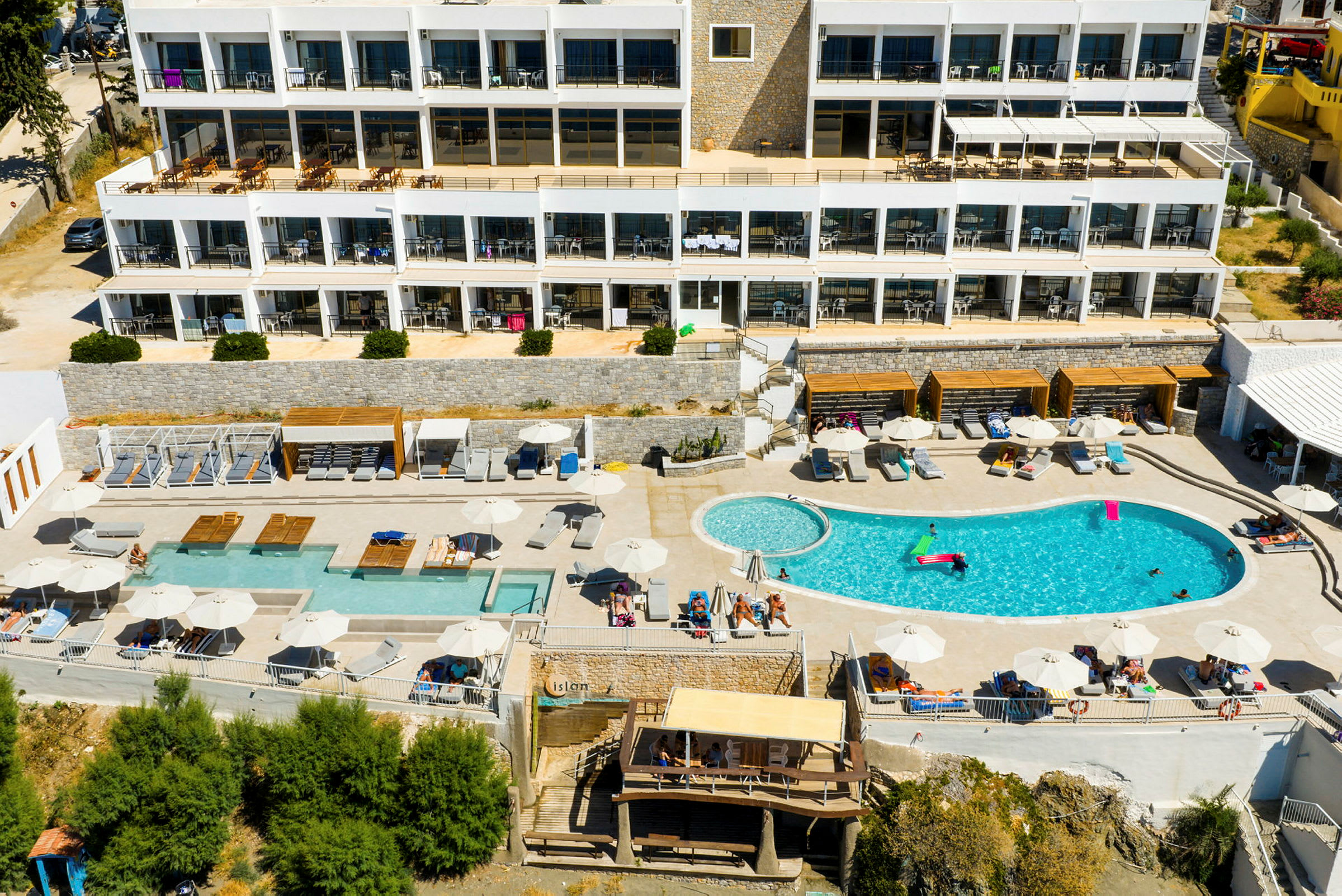 Luftvy av hotellområde med pool och solstolar. (AI-genererad text)