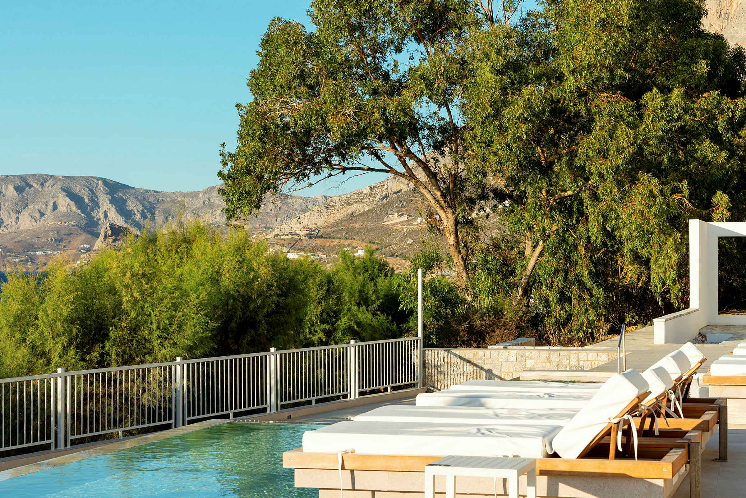 Pool vid ett hotell med utsikt över berg och grönska. (AI-genererad text)