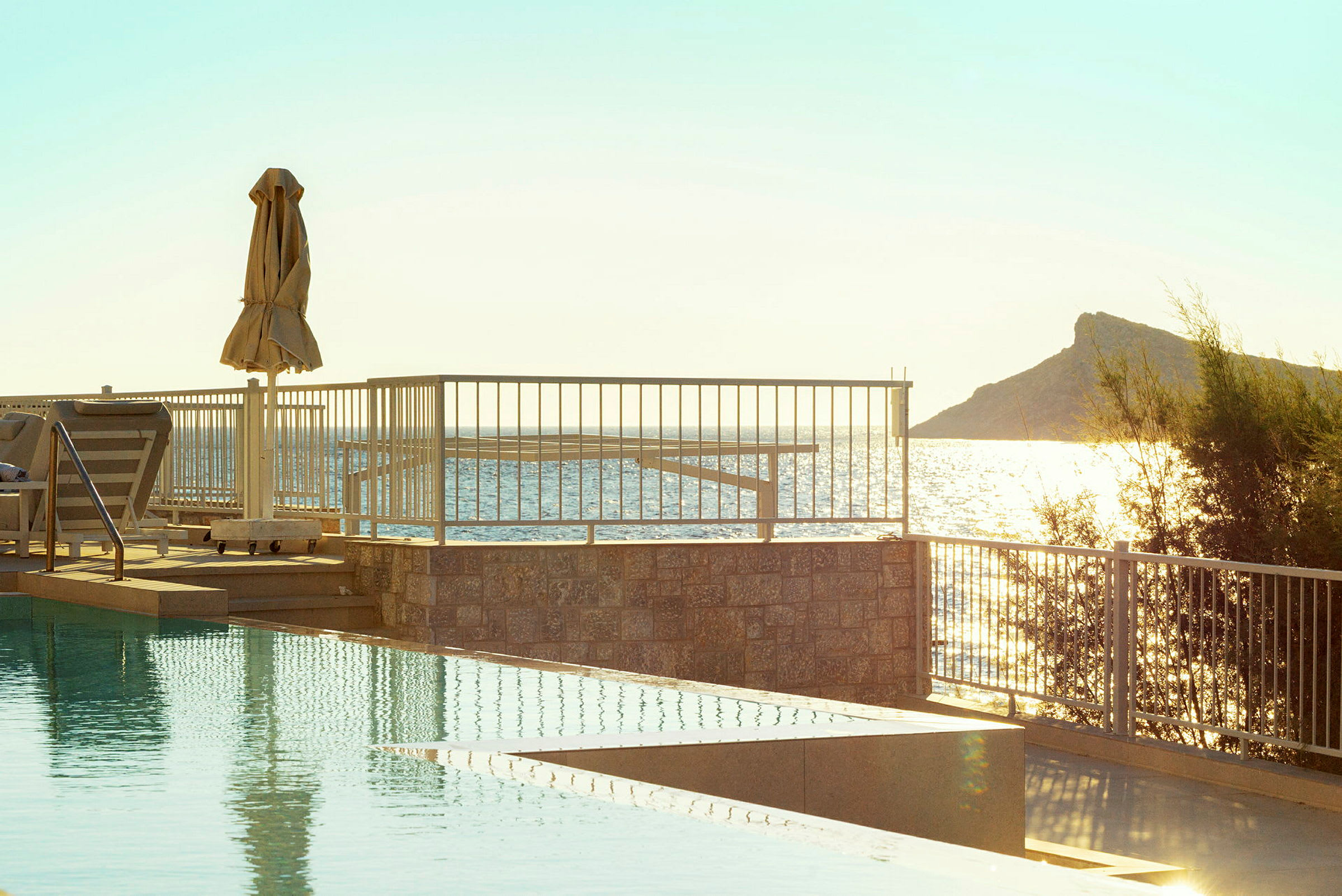 En pool med utsikt över havet och en solig himmel. (AI-genererad text)
