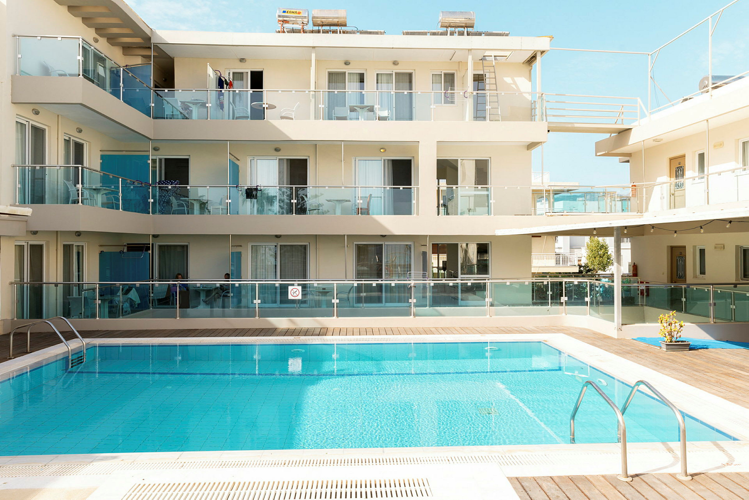 Bilden visar ett hotell med balkonger och en utomhuspool. (AI-genererad text)