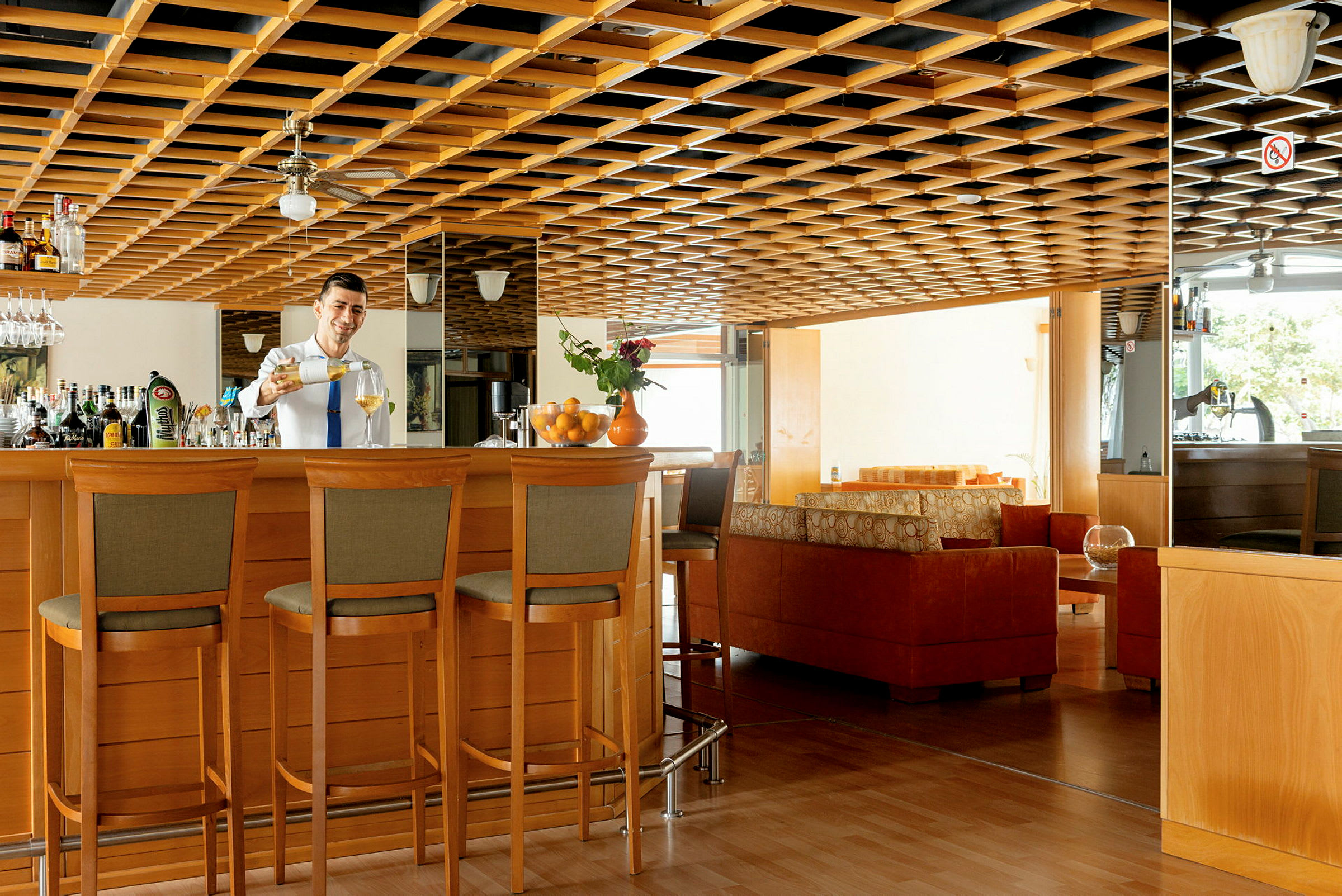 Modernt inrett hotellbar med trädetaljer och sittgrupper. (AI-genererad text)