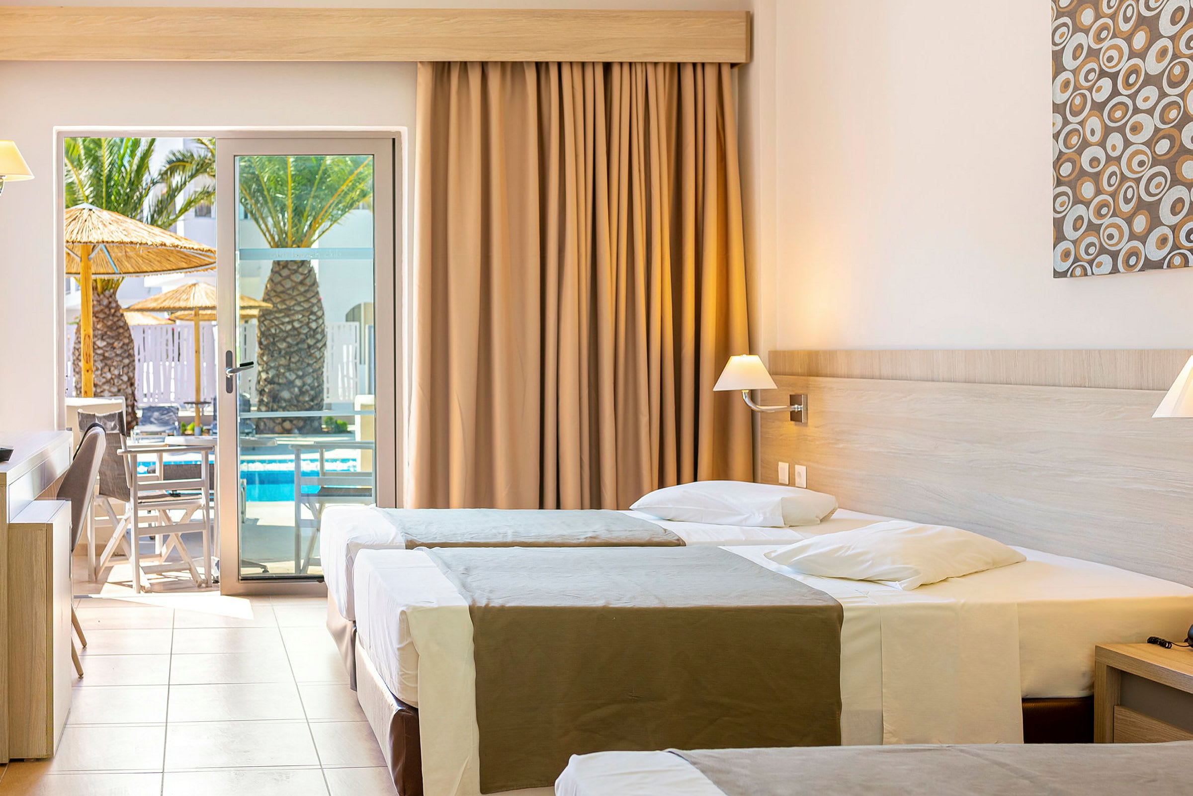 Hotellrum med tre sängar och en utgång till terrass med poolutsikt. (AI-genererad text)