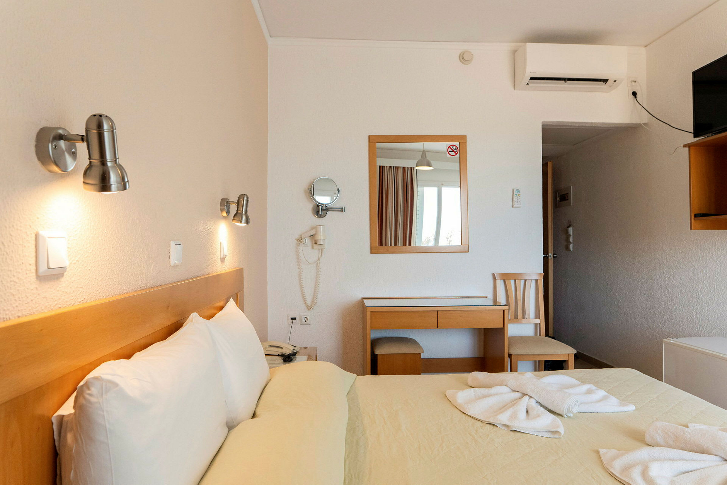 Hotellrum med dubbelsäng och skrivbord. (AI-genererad text)