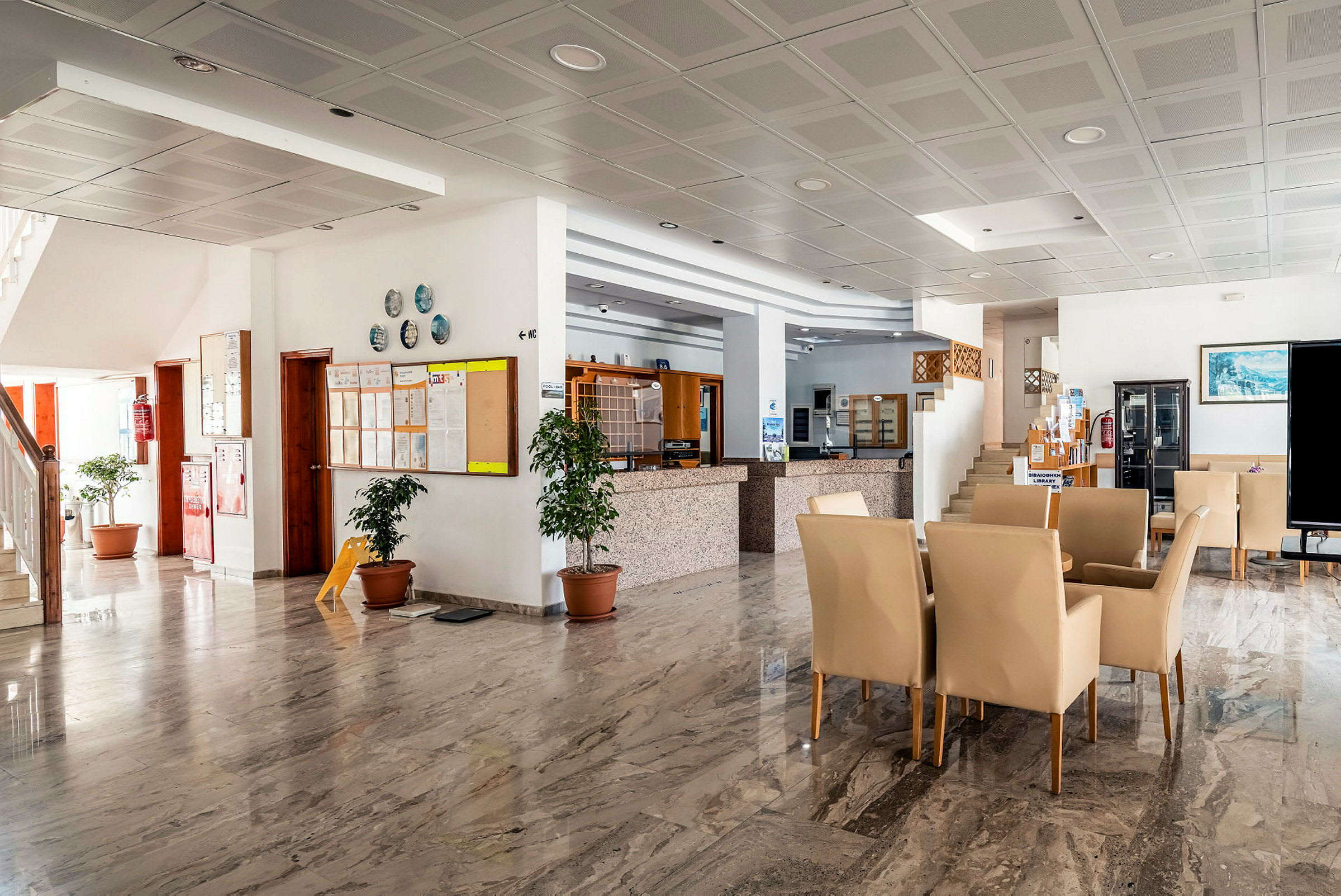 Interiör av ett hotell. Ljus lobby med marmorgolv och sittplatser. (AI-genererad text)