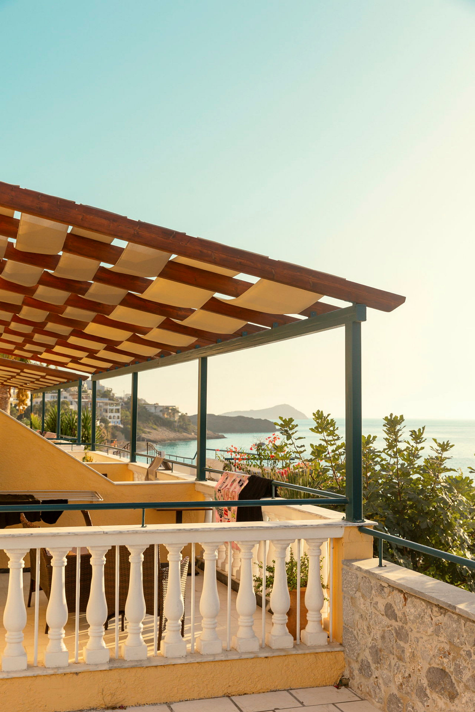 Utsikt från en terrass med pergola mot havet. (AI-genererad text)