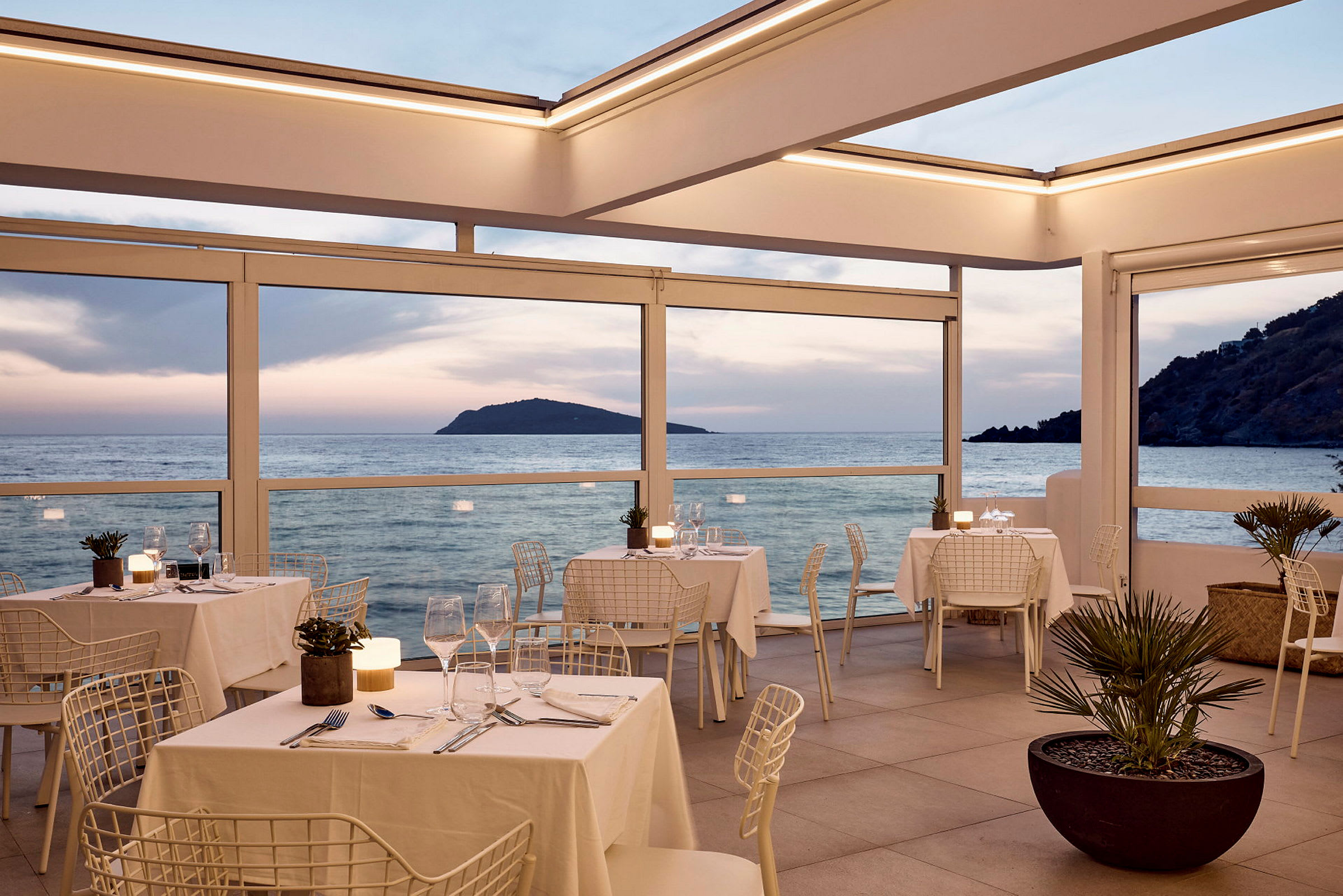 Restaurang med havsutsikt under solnedgången. (AI-genererad text)