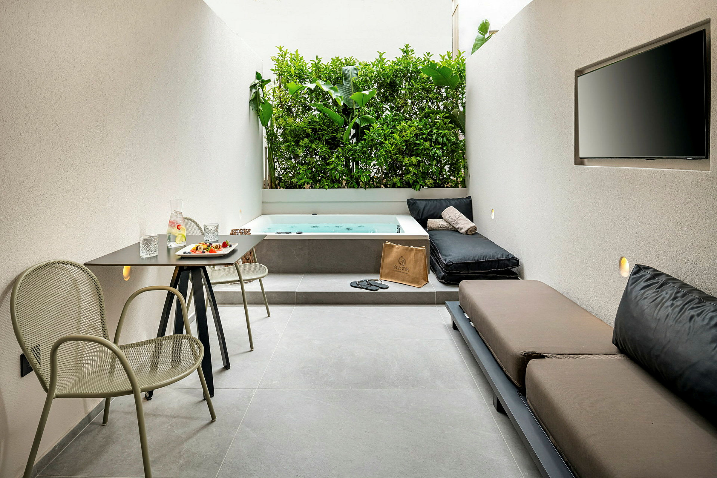 En modern uteplats med bord, stolar, soffa, jacuzzi och grönskande vägg. (AI-genererad text)