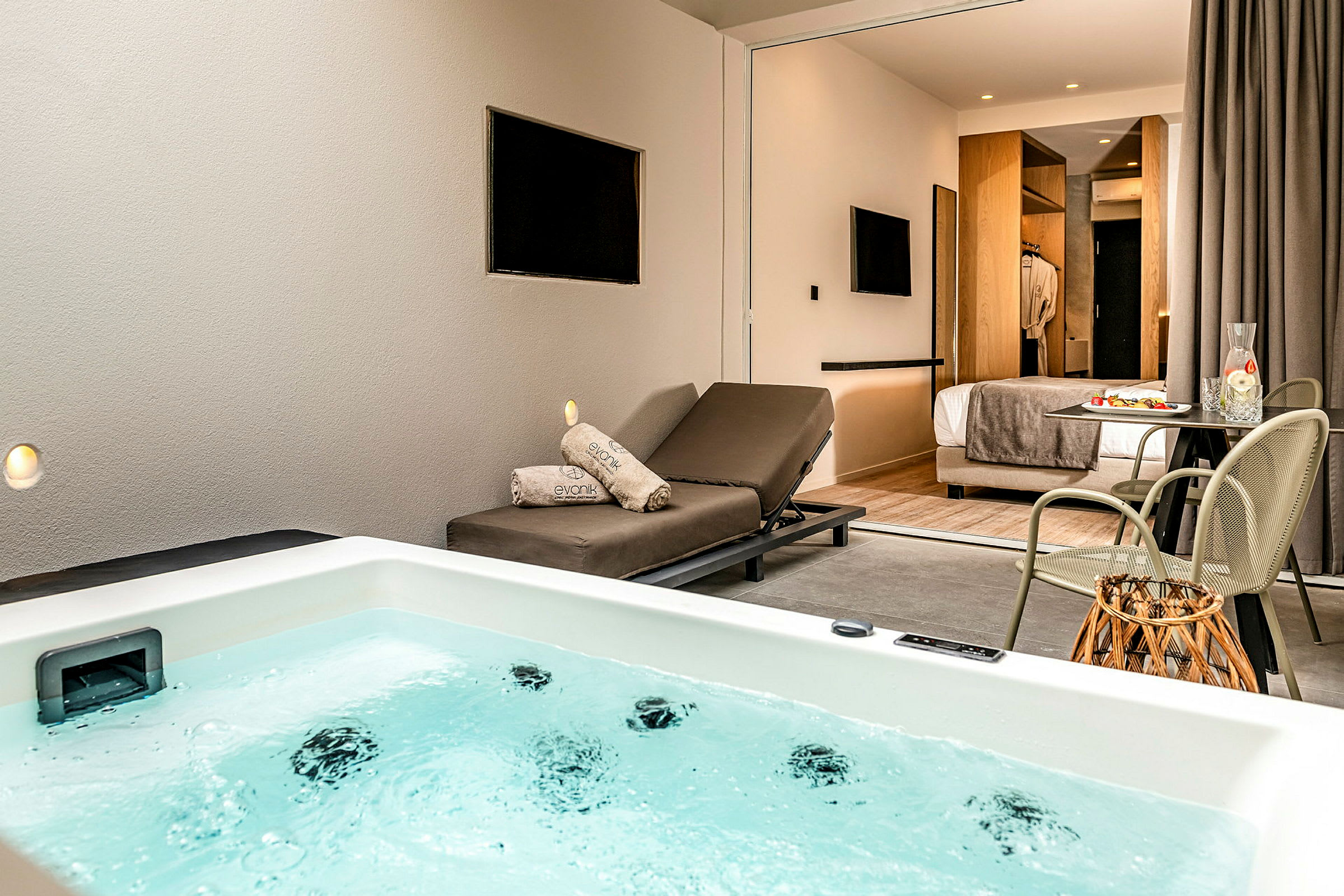 Ett hotellrum med egen badtunna i förgrunden och en solstol samt matbord i rummet. (AI-genererad text)
