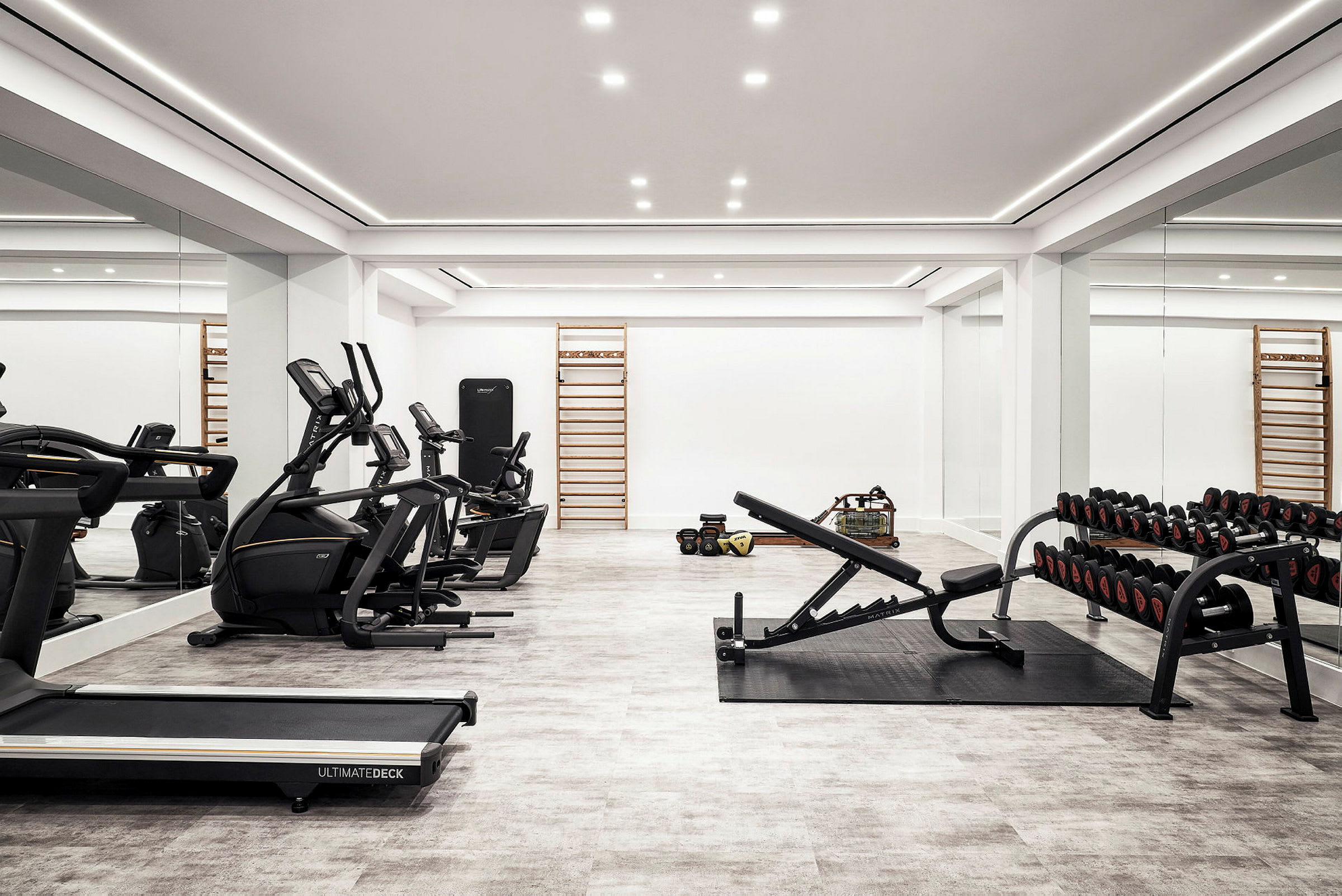 Gym med träningsutrustning, inklusive löpband, motionscyklar, vikter och bänkpress. (AI-genererad text)